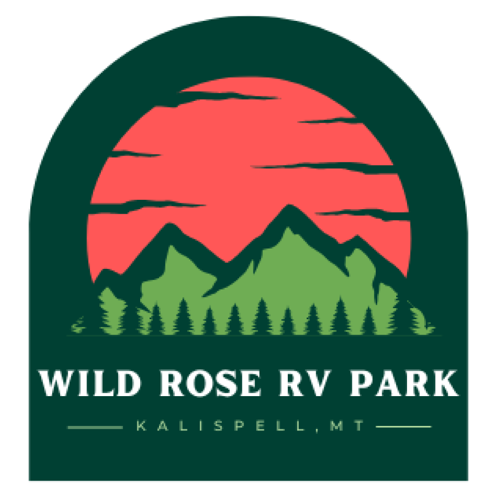Logo for Wild Rose RV Park in Kalispell, MT. Features mountains, sunset, and trees in a green and red color scheme.