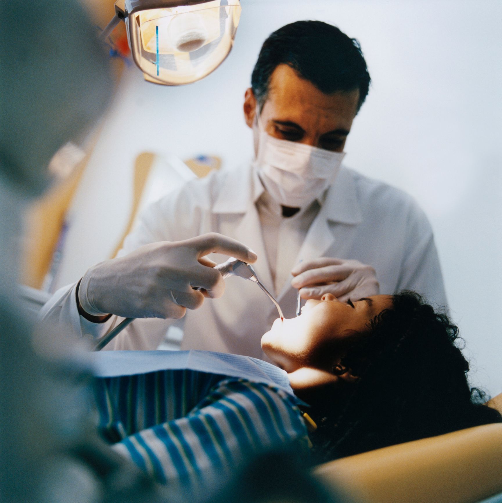 Un dentista esamina i denti di una ragazza su una poltrona odontoiatrica