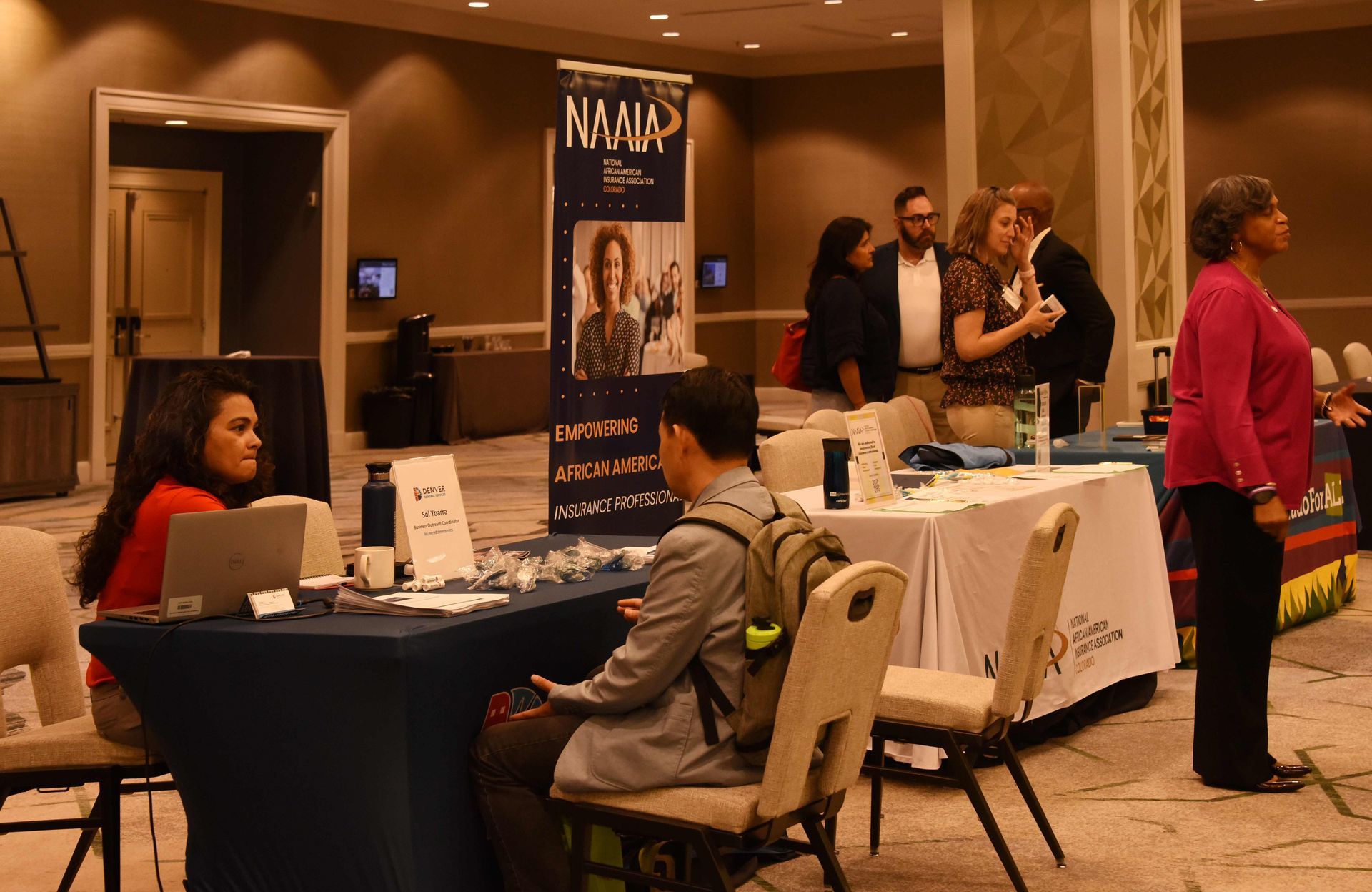 A group of people are standing around tables at a job fair.