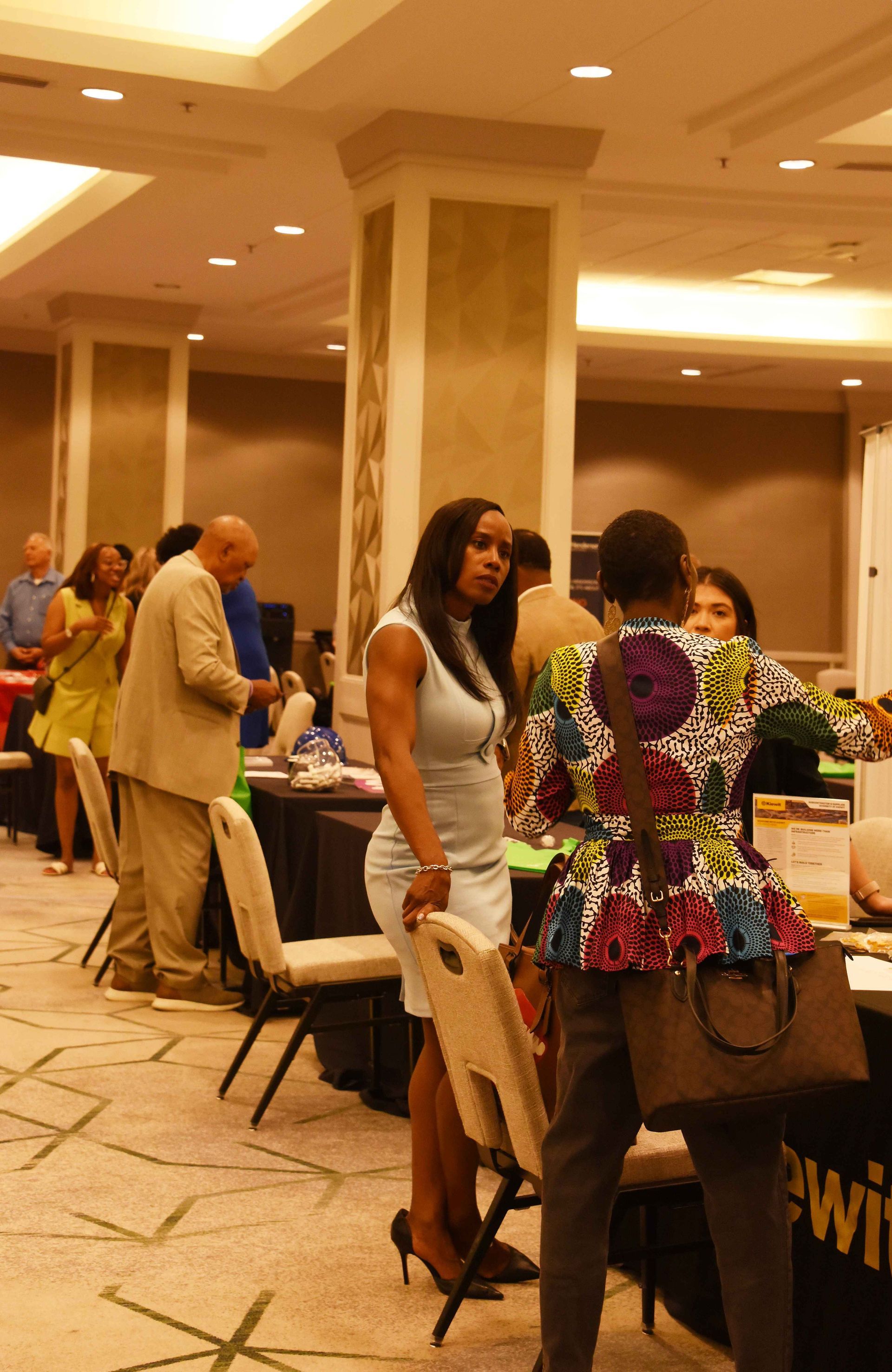 A woman is standing in front of a table that says pwi
