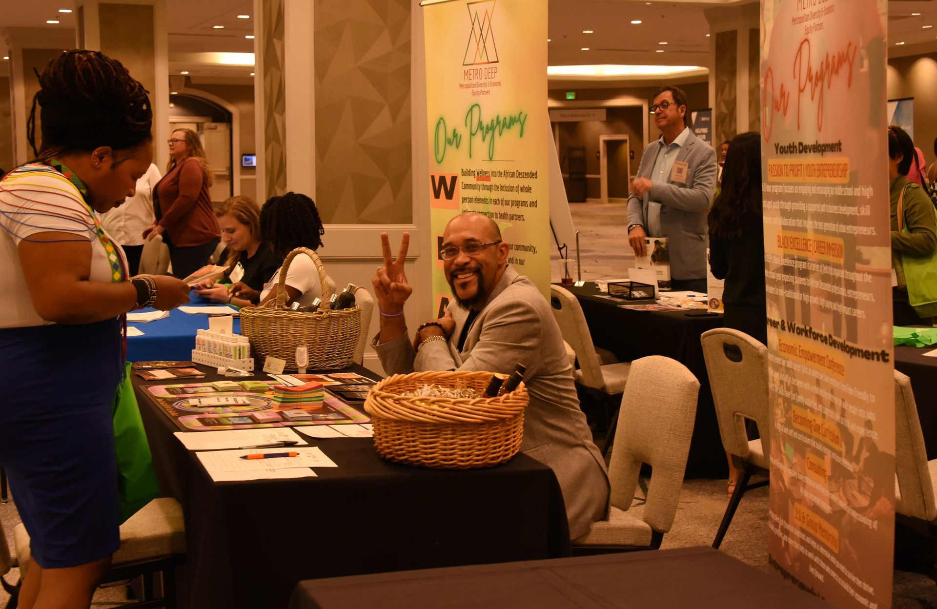 A man is sitting at a table giving a peace sign.