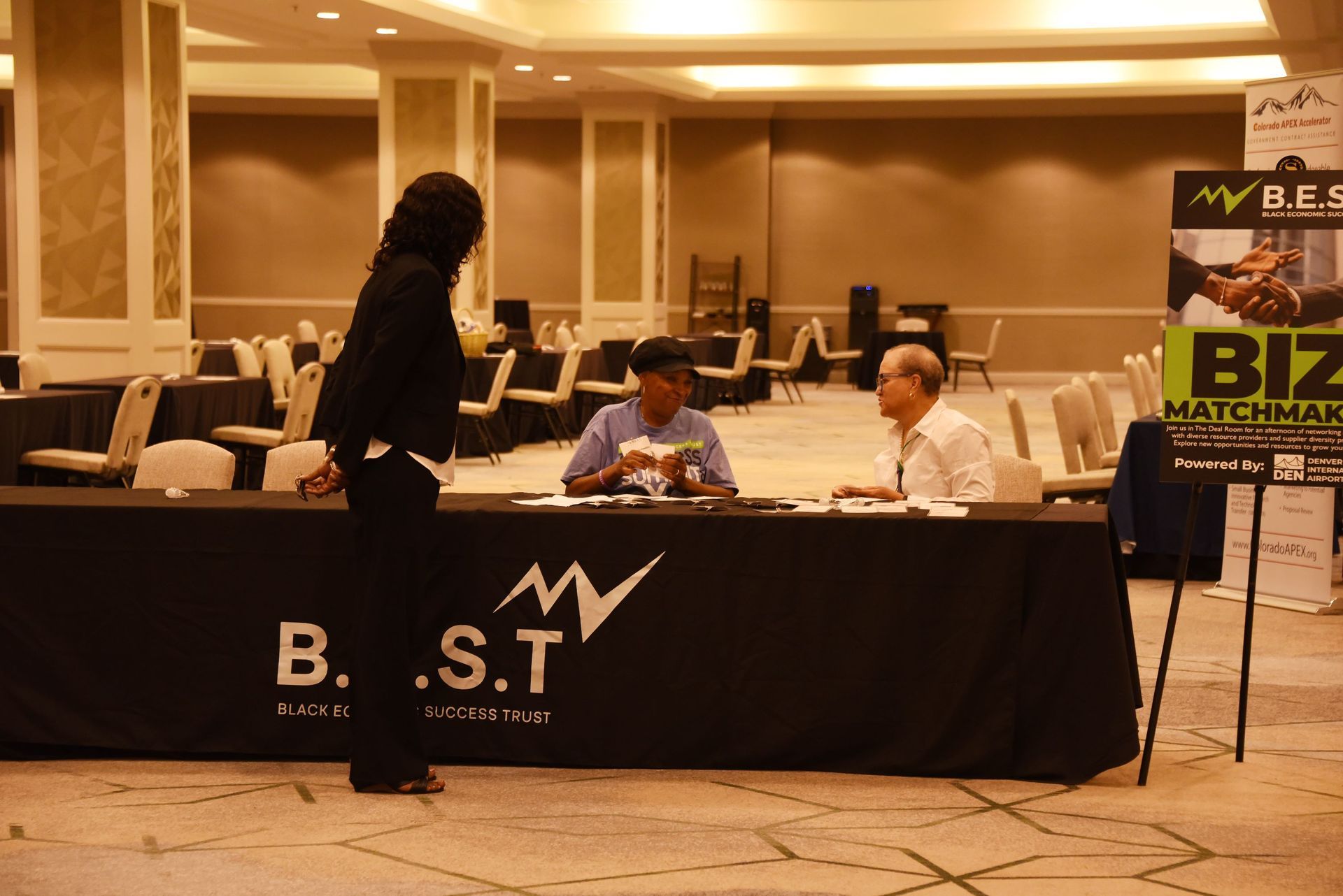 A woman standing next to a table that says b.s.t.