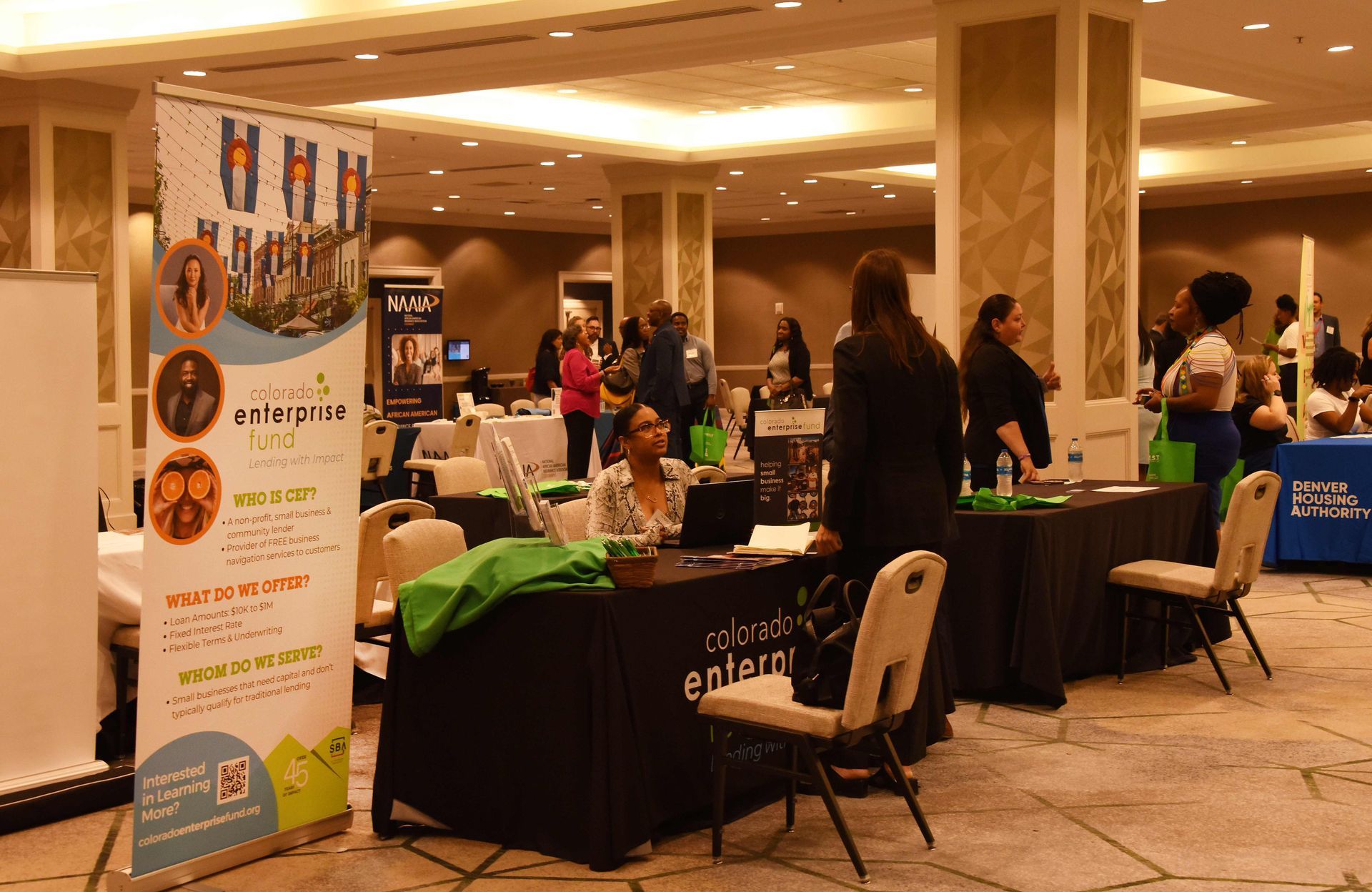 A group of people are standing around tables at a job fair.