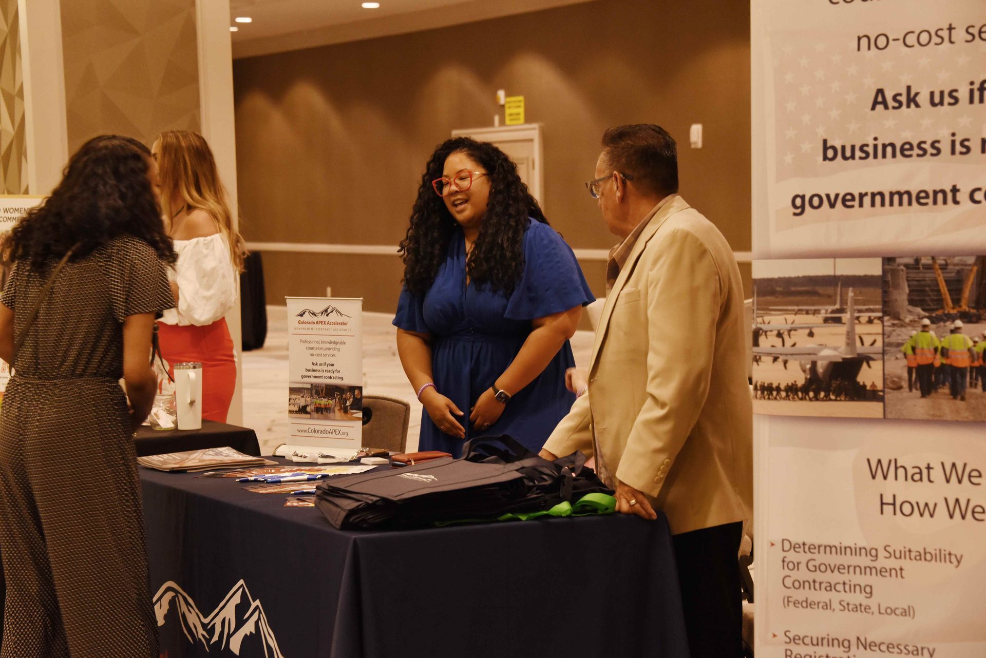 A group of people are standing around a table at a job fair.