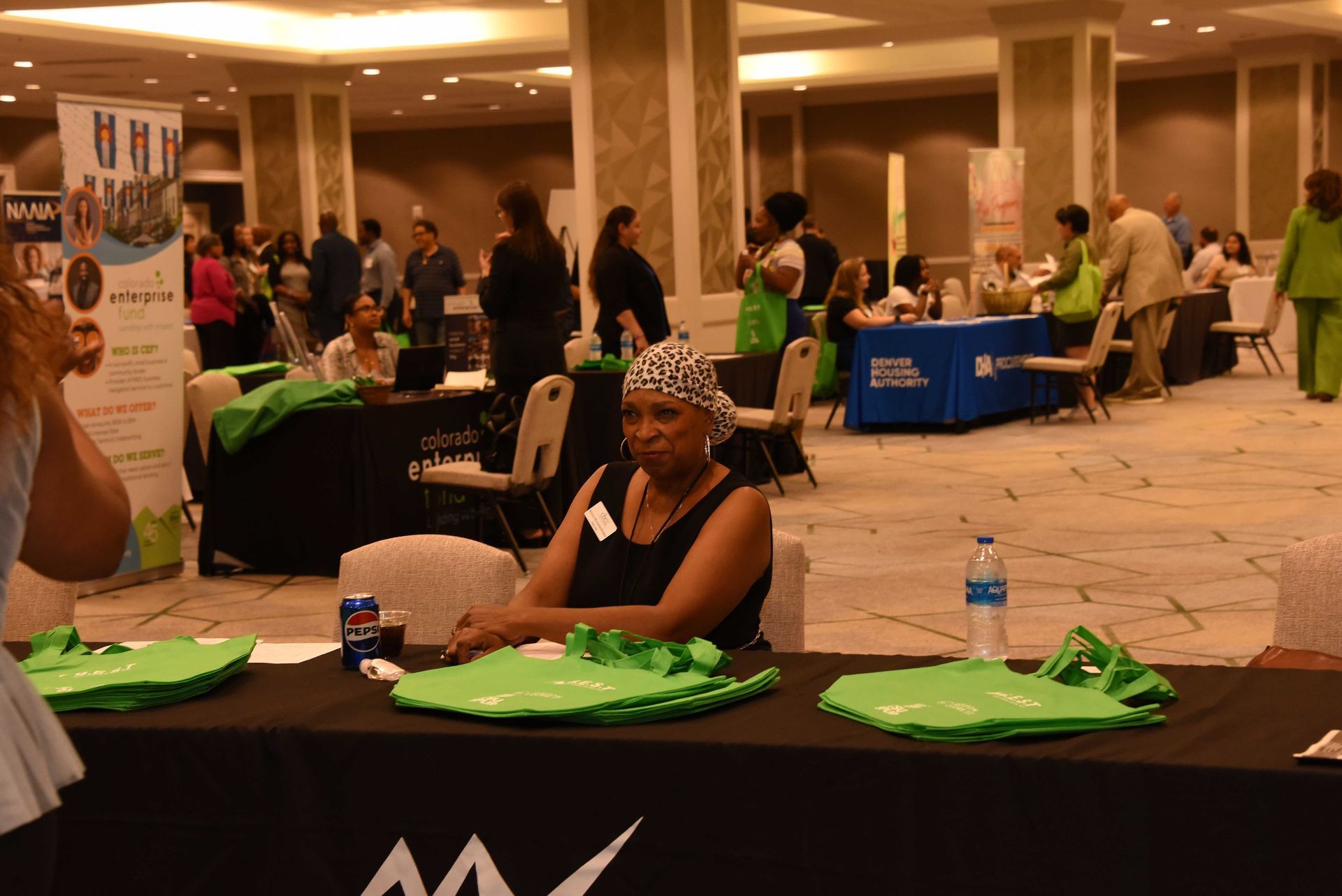 A woman is sitting at a table at a job fair.