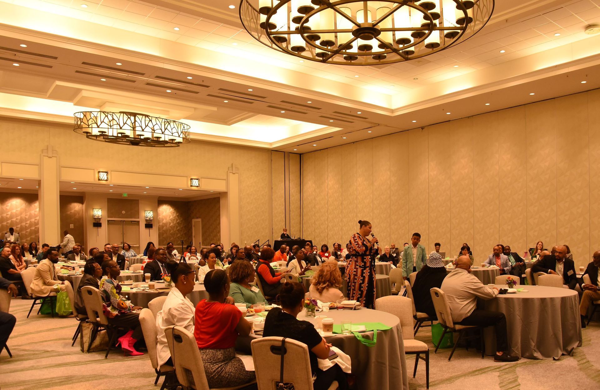 A group of people are sitting at tables in a large room