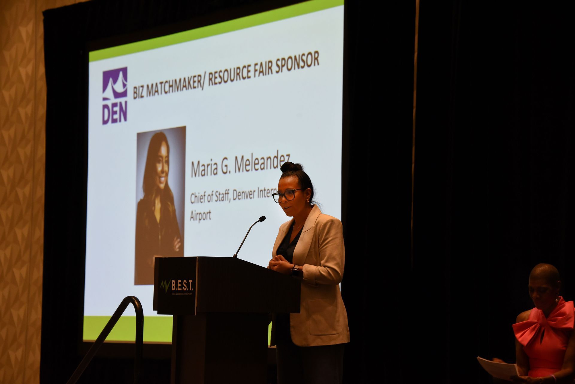 A woman is standing at a podium giving a presentation