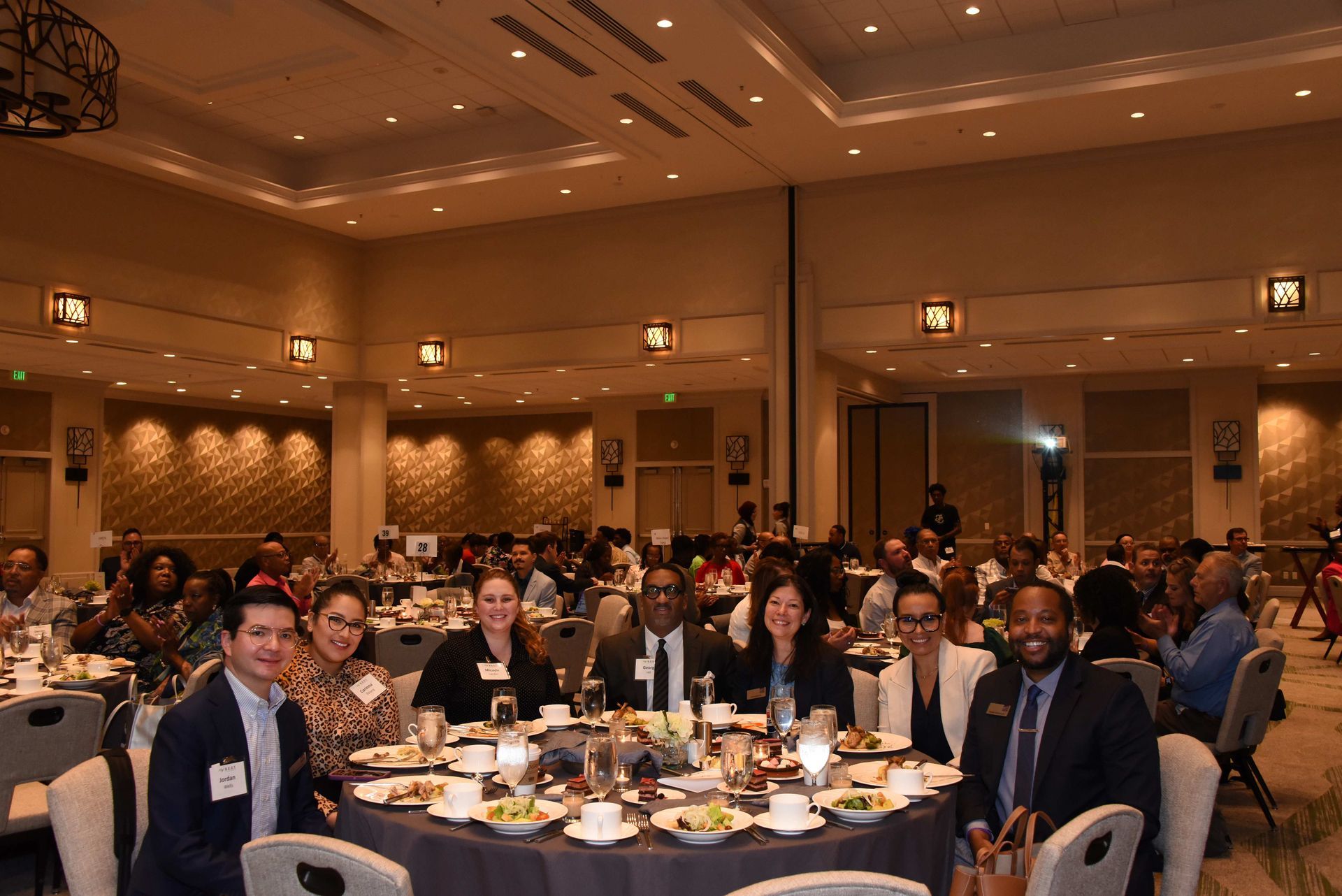 A group of people are sitting at tables in a large room.