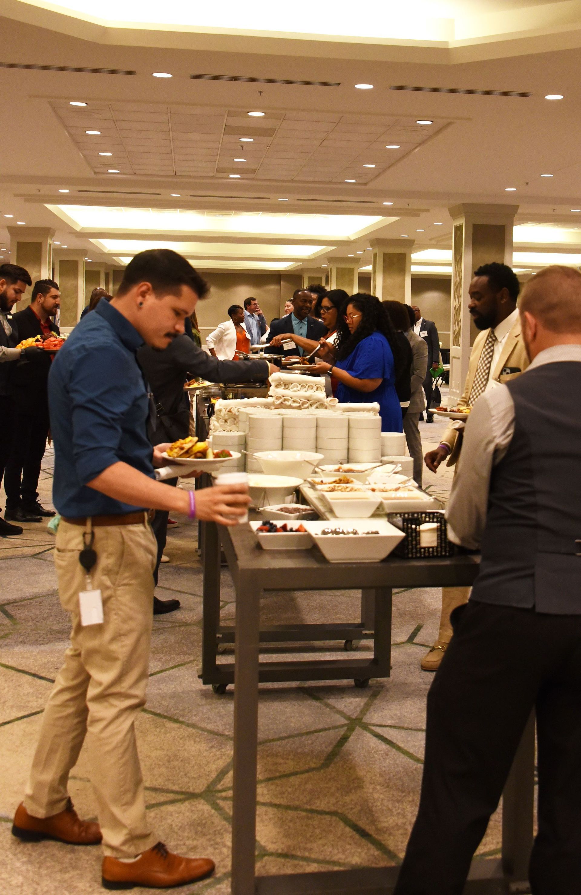 A group of people are standing around a buffet table