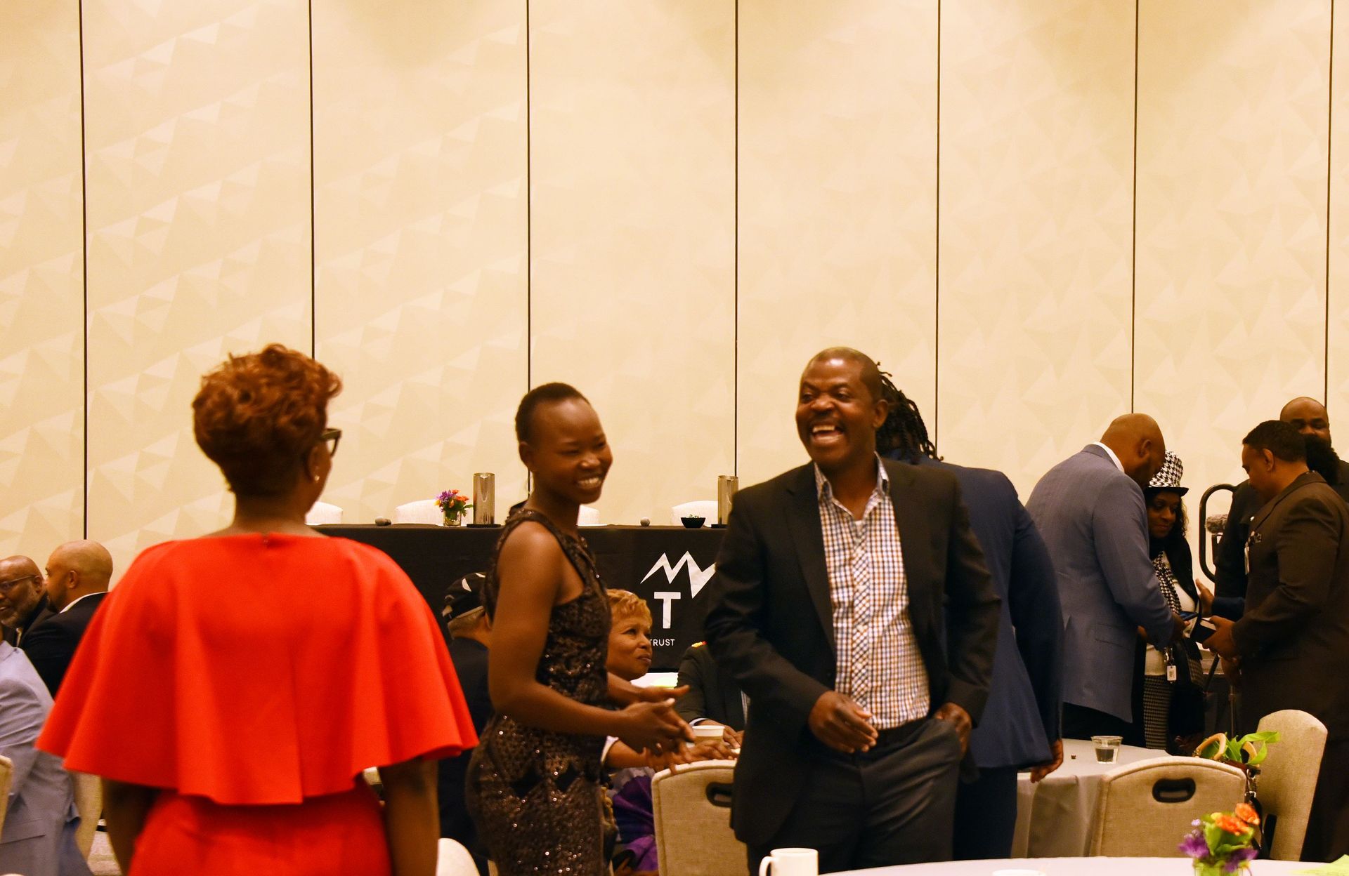 A group of people are standing around a table in a room.