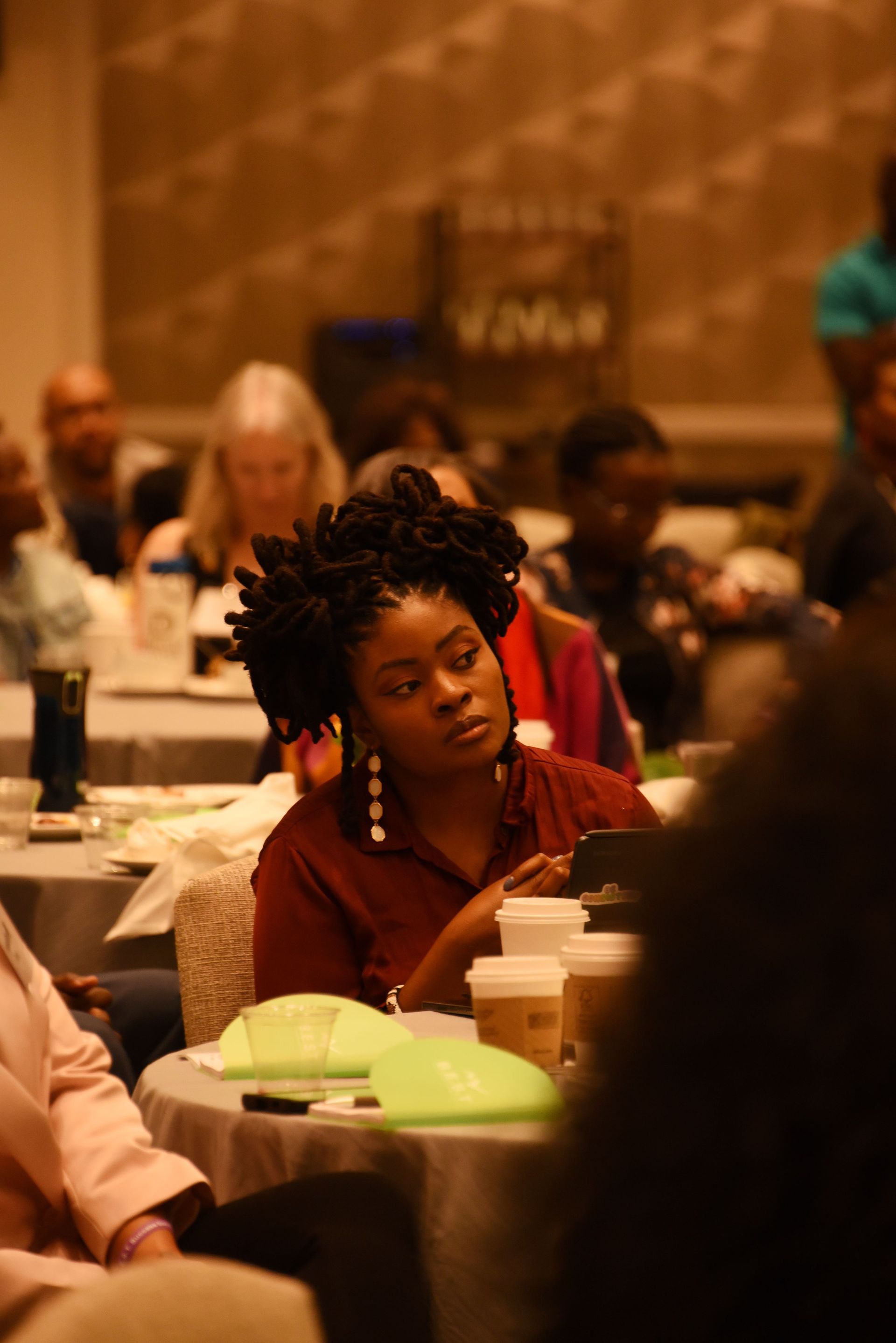 A group of people are sitting at tables in a room.