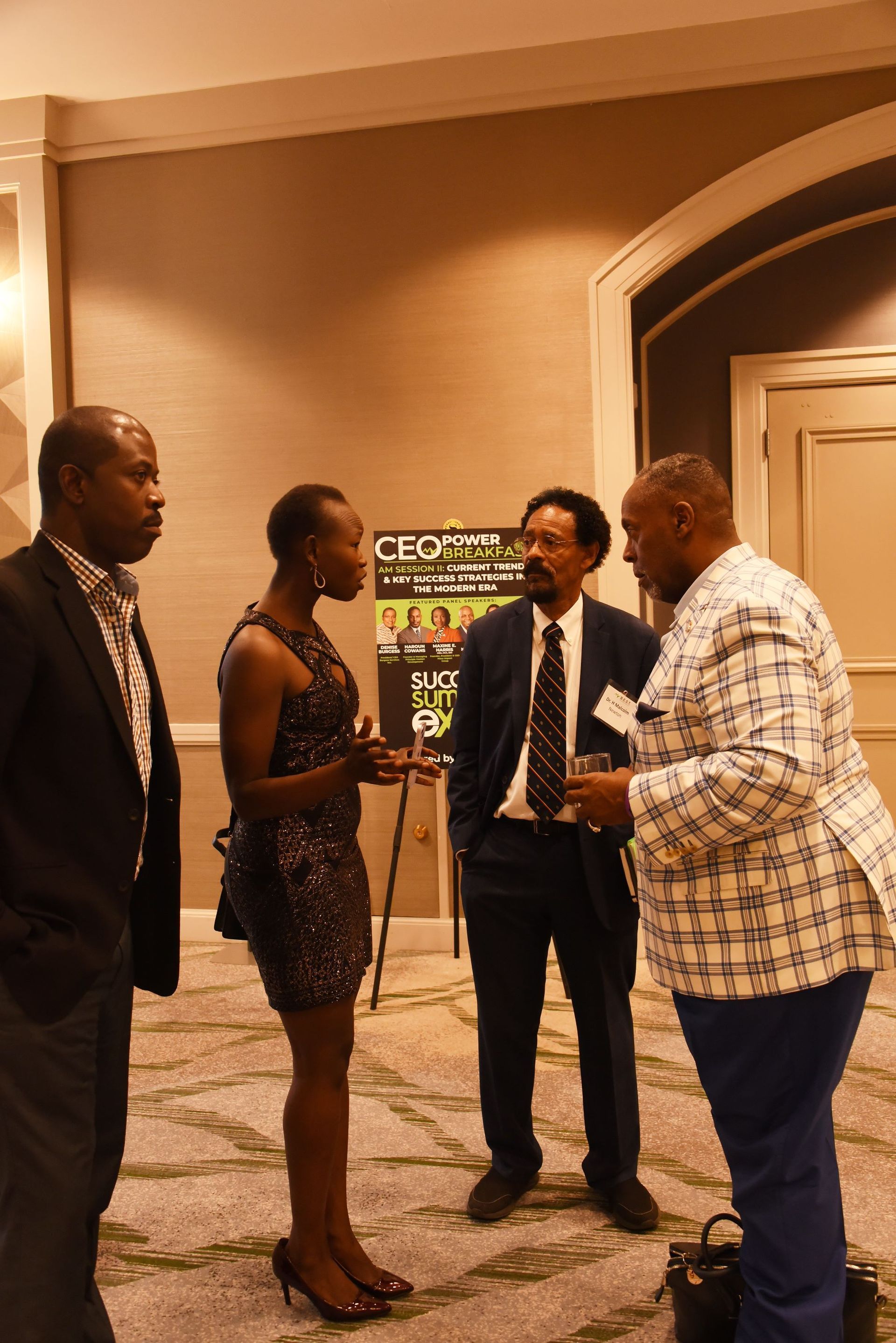 A group of people are standing in a room with a sign that says ceo on it