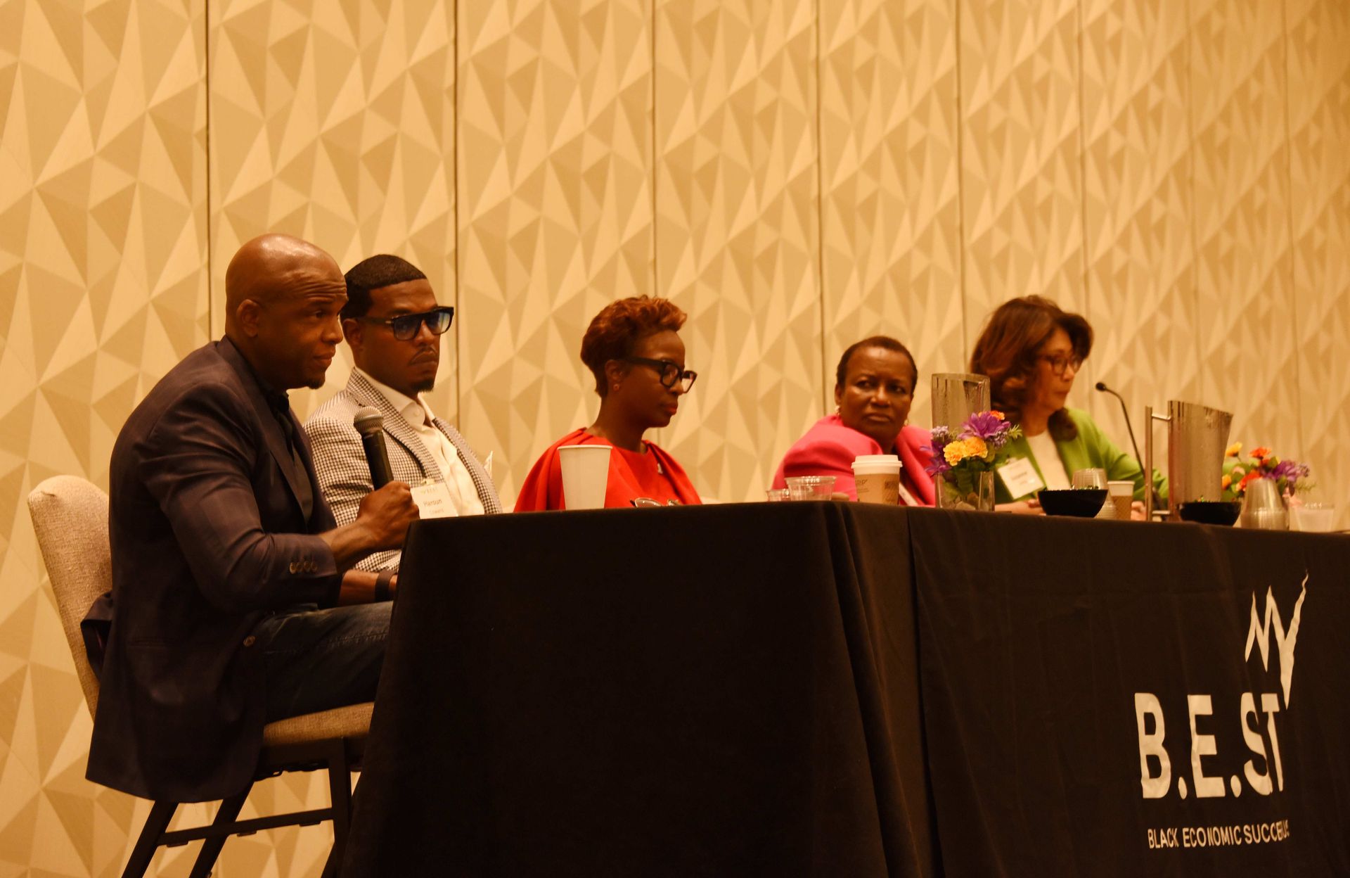 A group of people are sitting at a table with microphones.