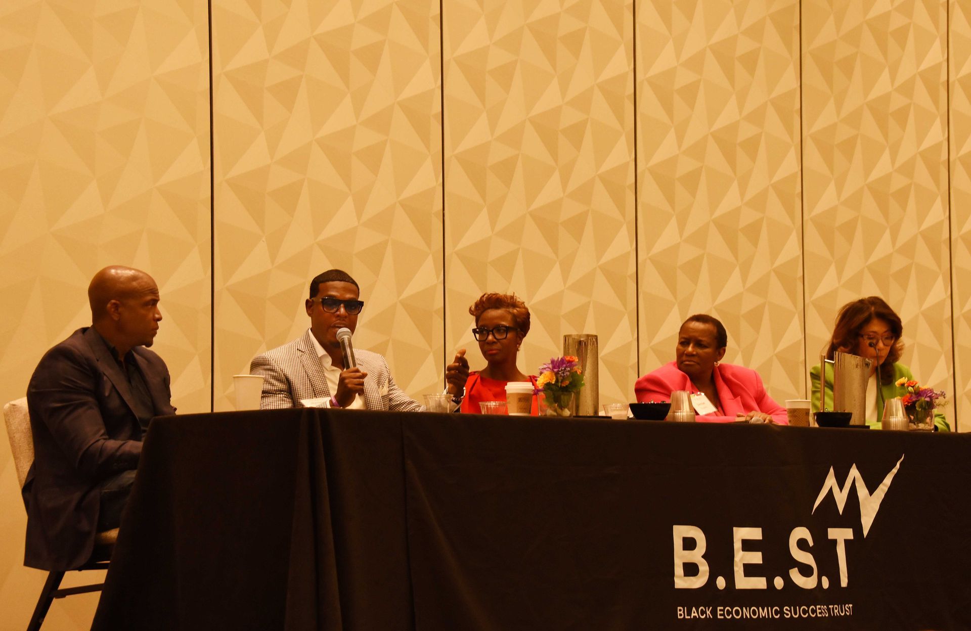 A group of people sitting at a table with a sign that says b.e.s.t.