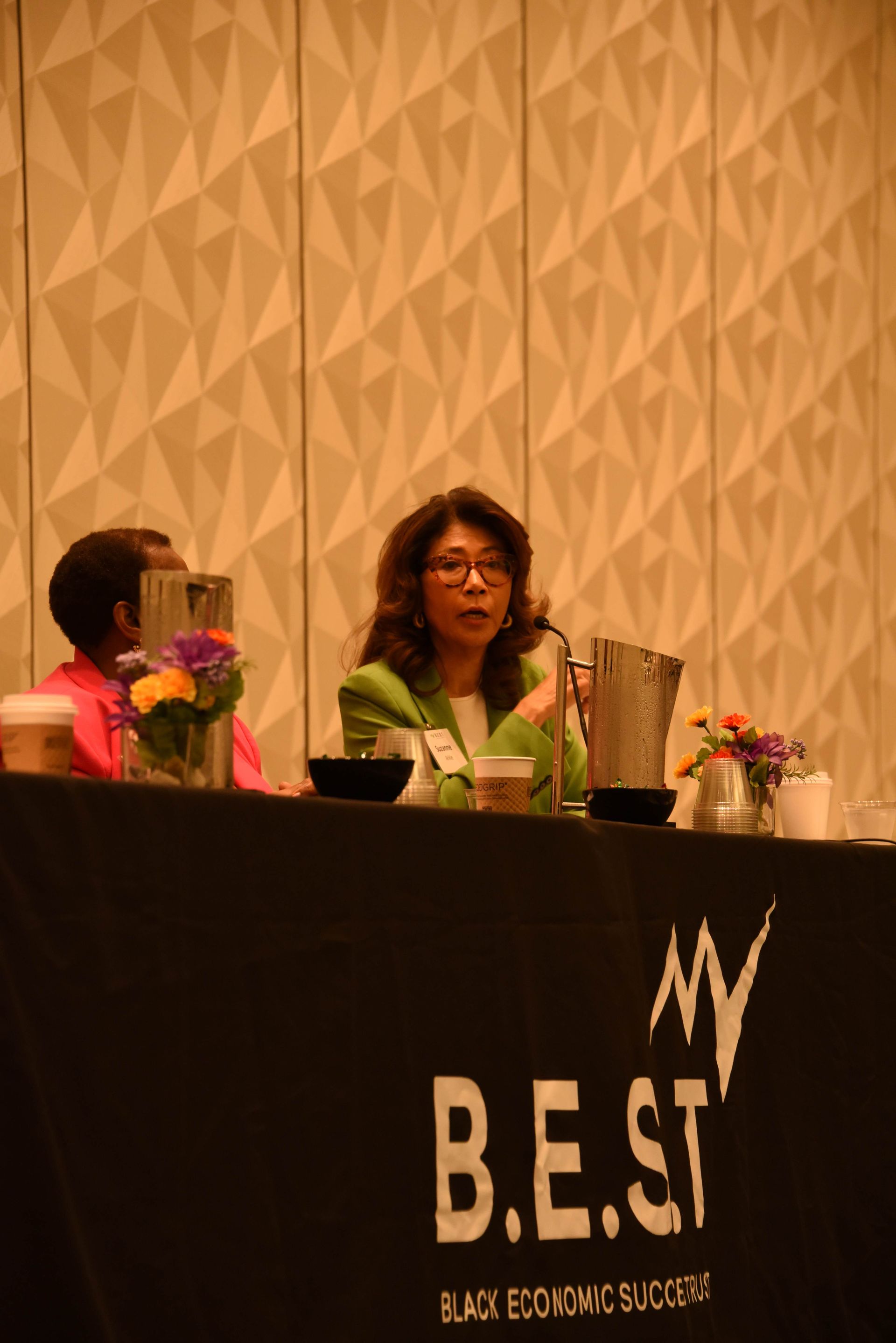A woman is giving a speech at a b.e.st conference