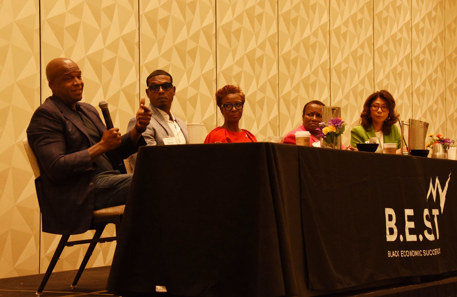 A group of people are sitting at a table with a sign that says b.e.s.f.