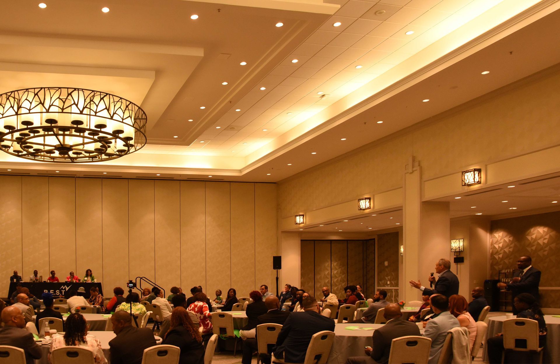 A group of people are sitting at tables in a large room