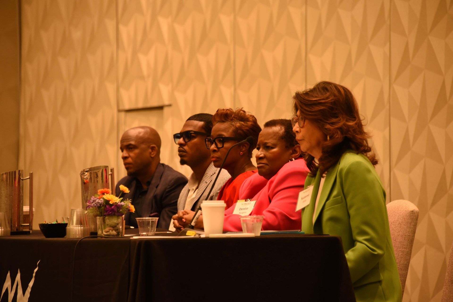 A group of people are sitting at a table at a conference.