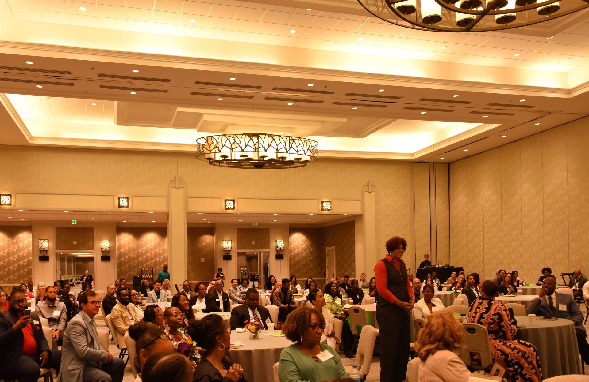 A group of people are sitting at tables in a large room
