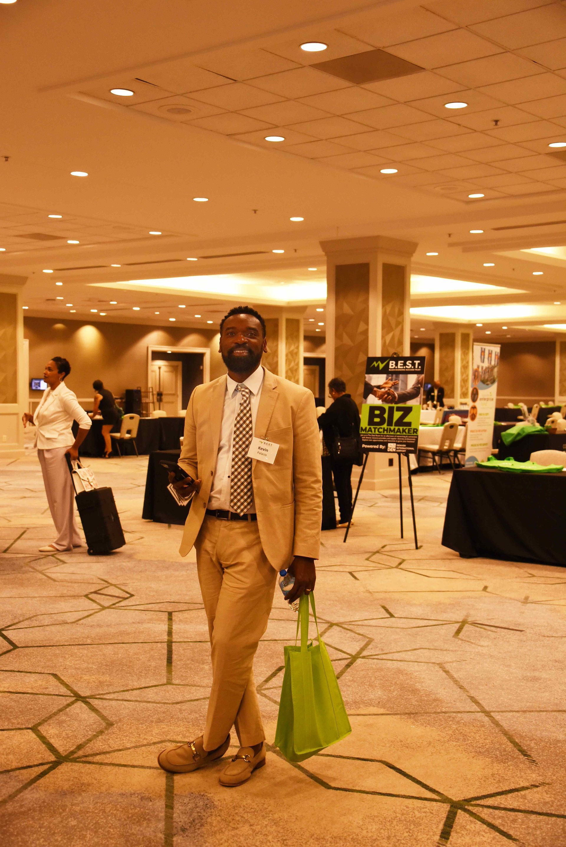 A man in a suit and tie is standing in a large room