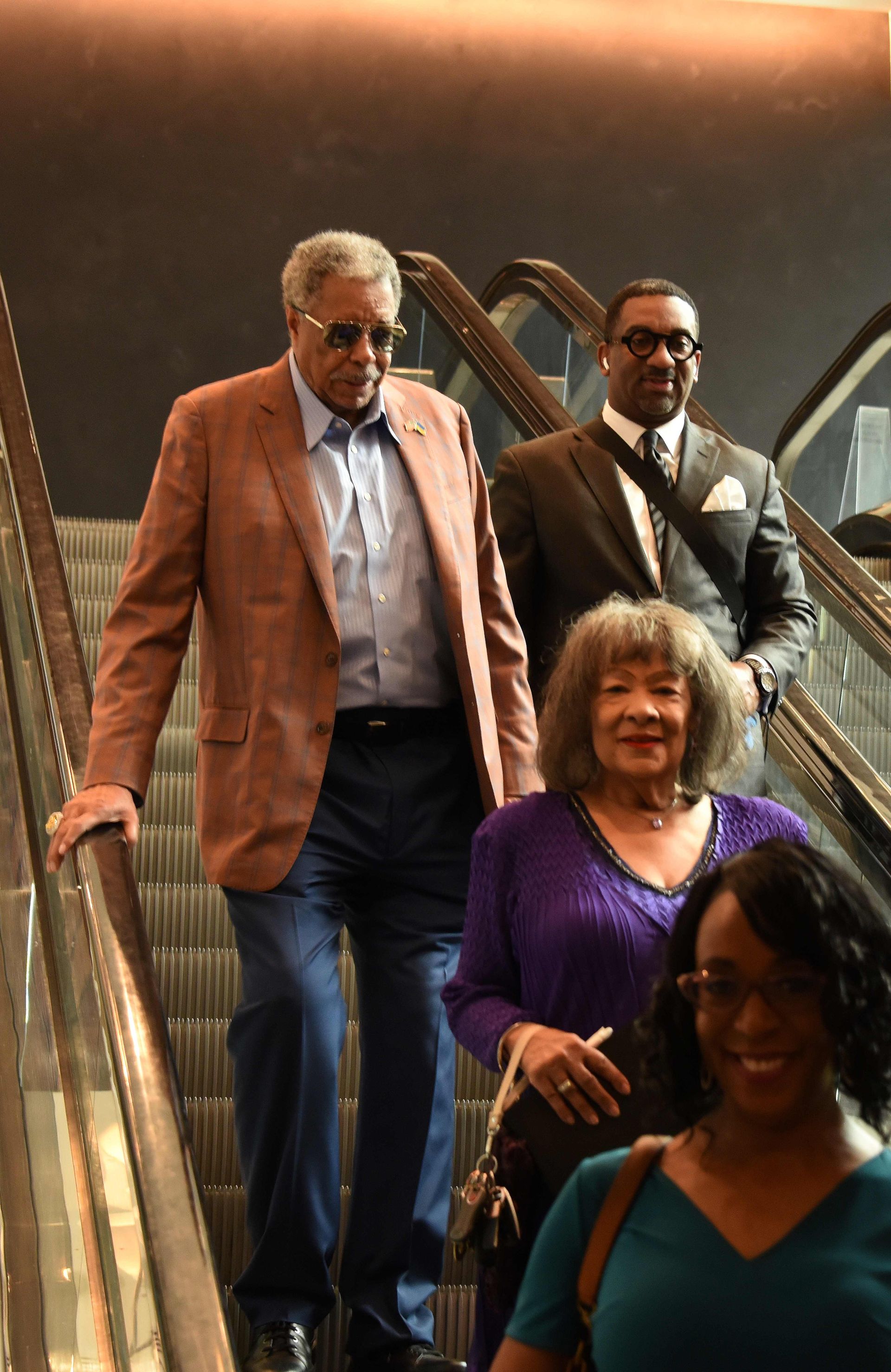 A group of people are walking up a set of escalators