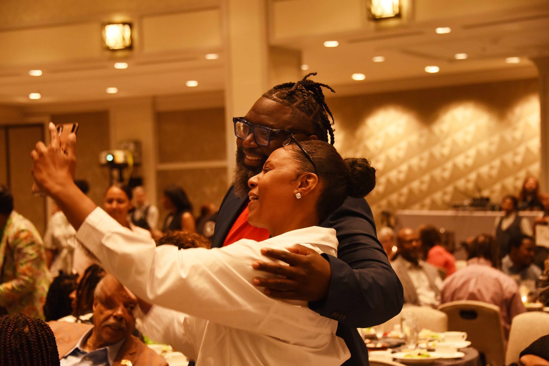 A man is hugging a woman in a room at a party.