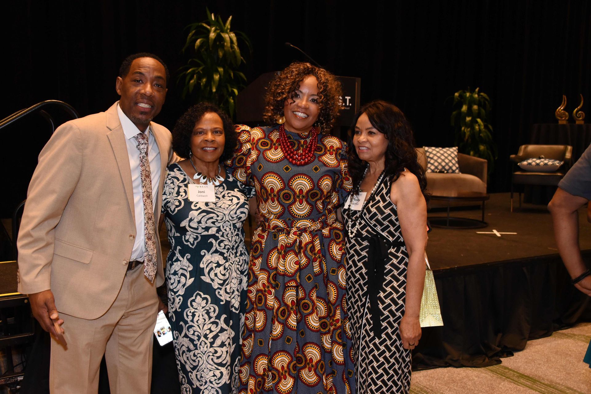 A group of people are posing for a picture in front of a stage.