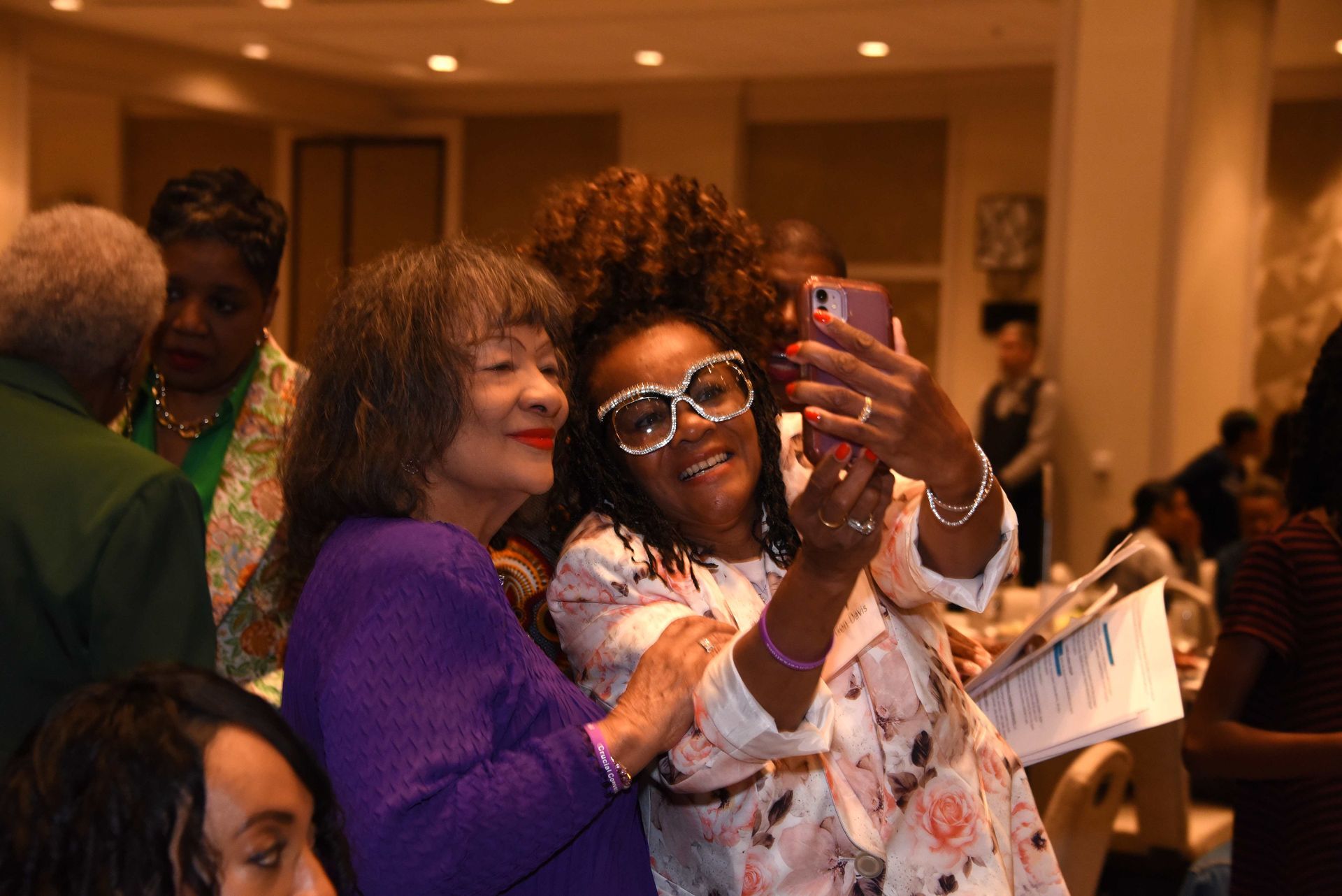 Two women are taking a selfie together at a party.