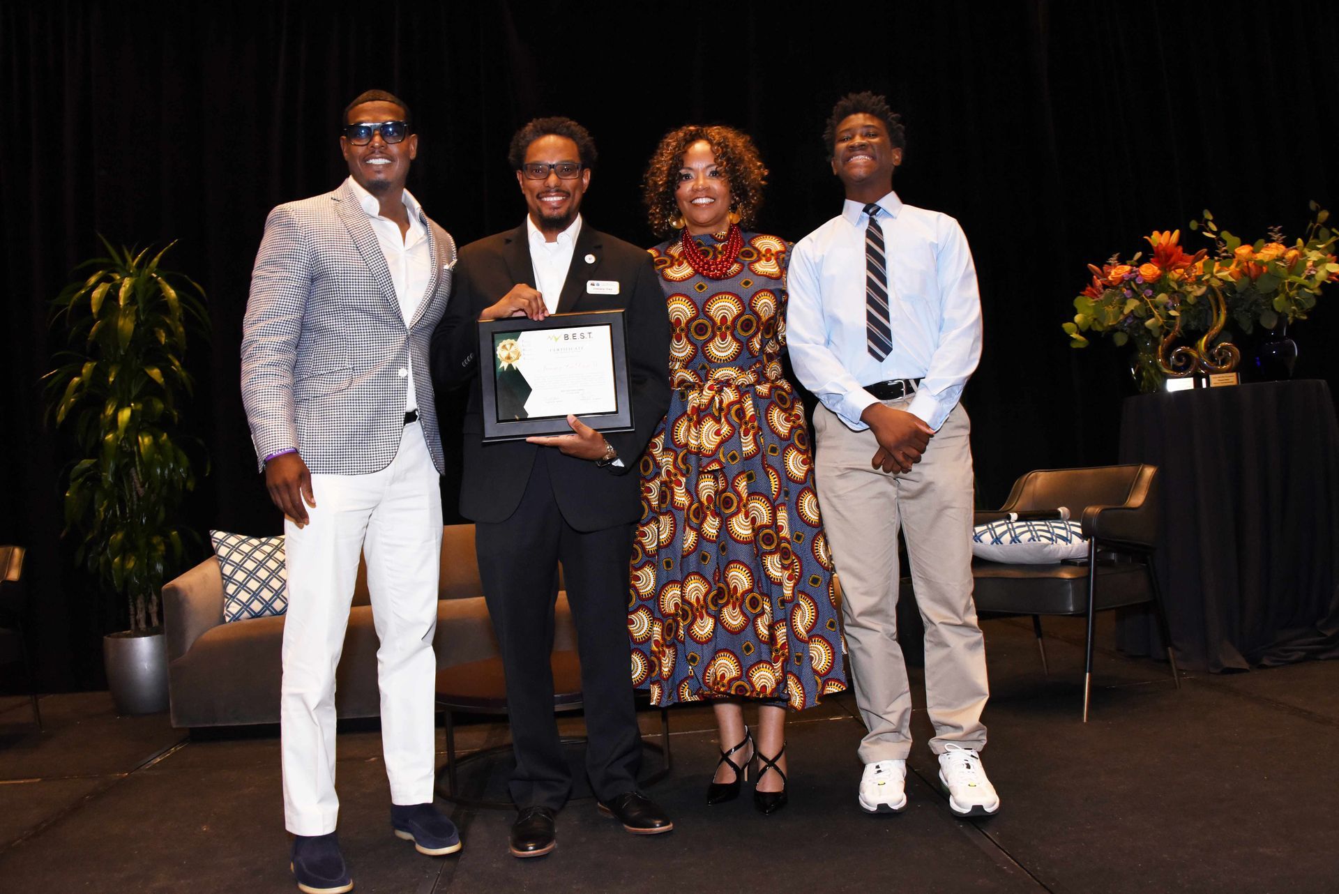 A group of people standing next to each other on a stage holding a certificate.
