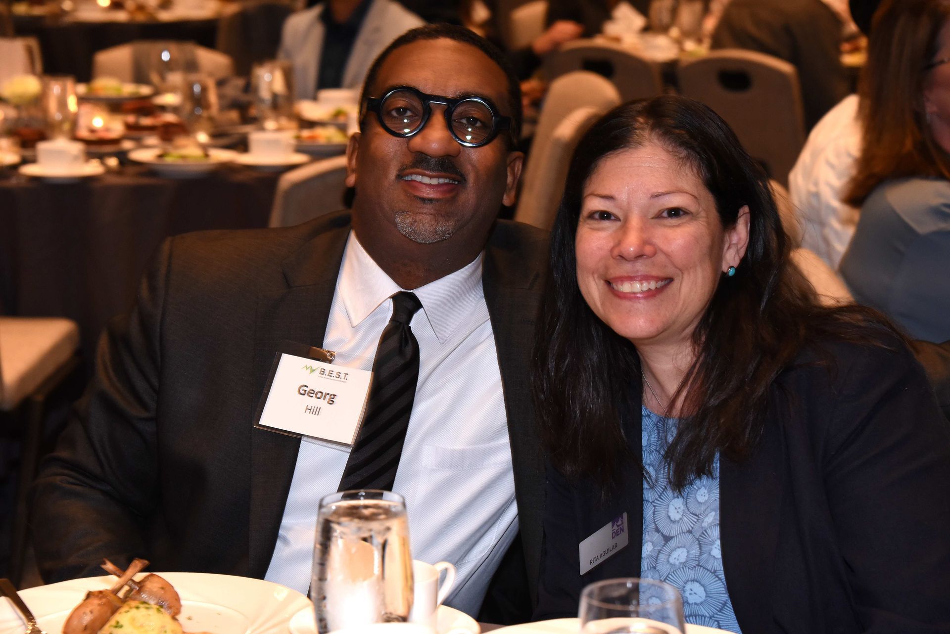 A man and a woman are posing for a picture at a table