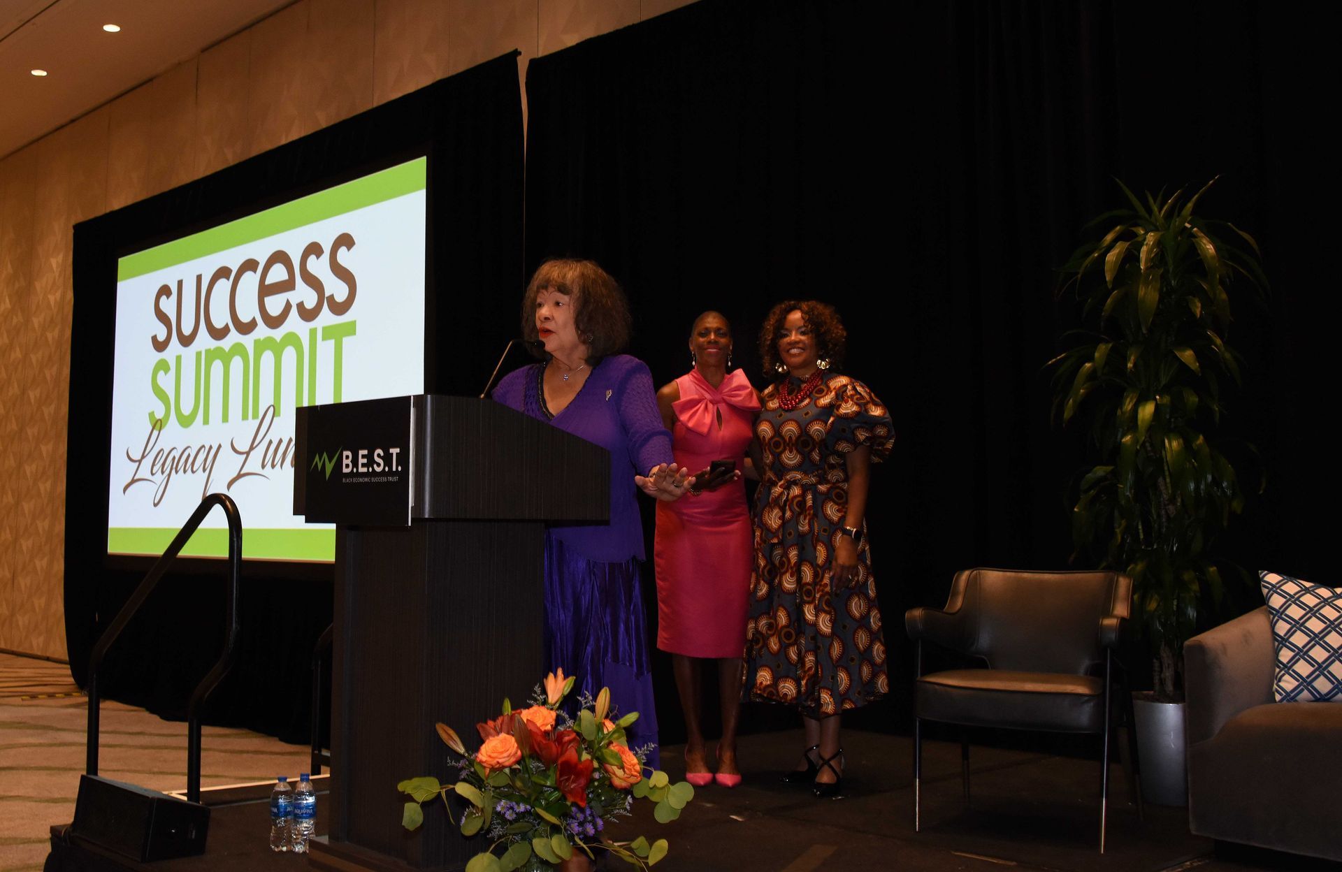 A woman is standing at a podium giving a speech at a success summit.