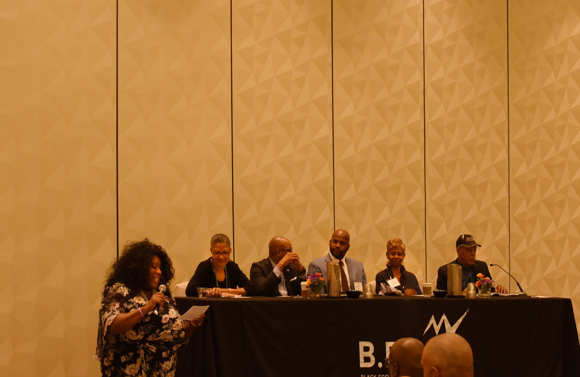 A group of people are sitting at a table with microphones.