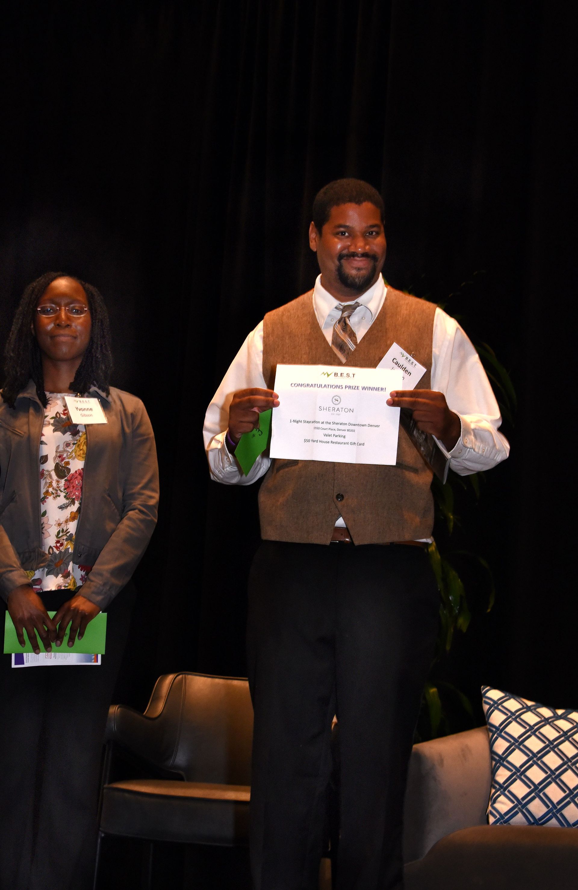 A man and a woman are standing next to each other holding a certificate.