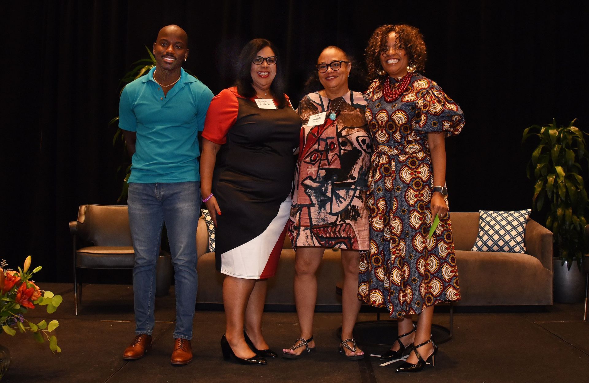 A group of people are posing for a picture in front of a couch.