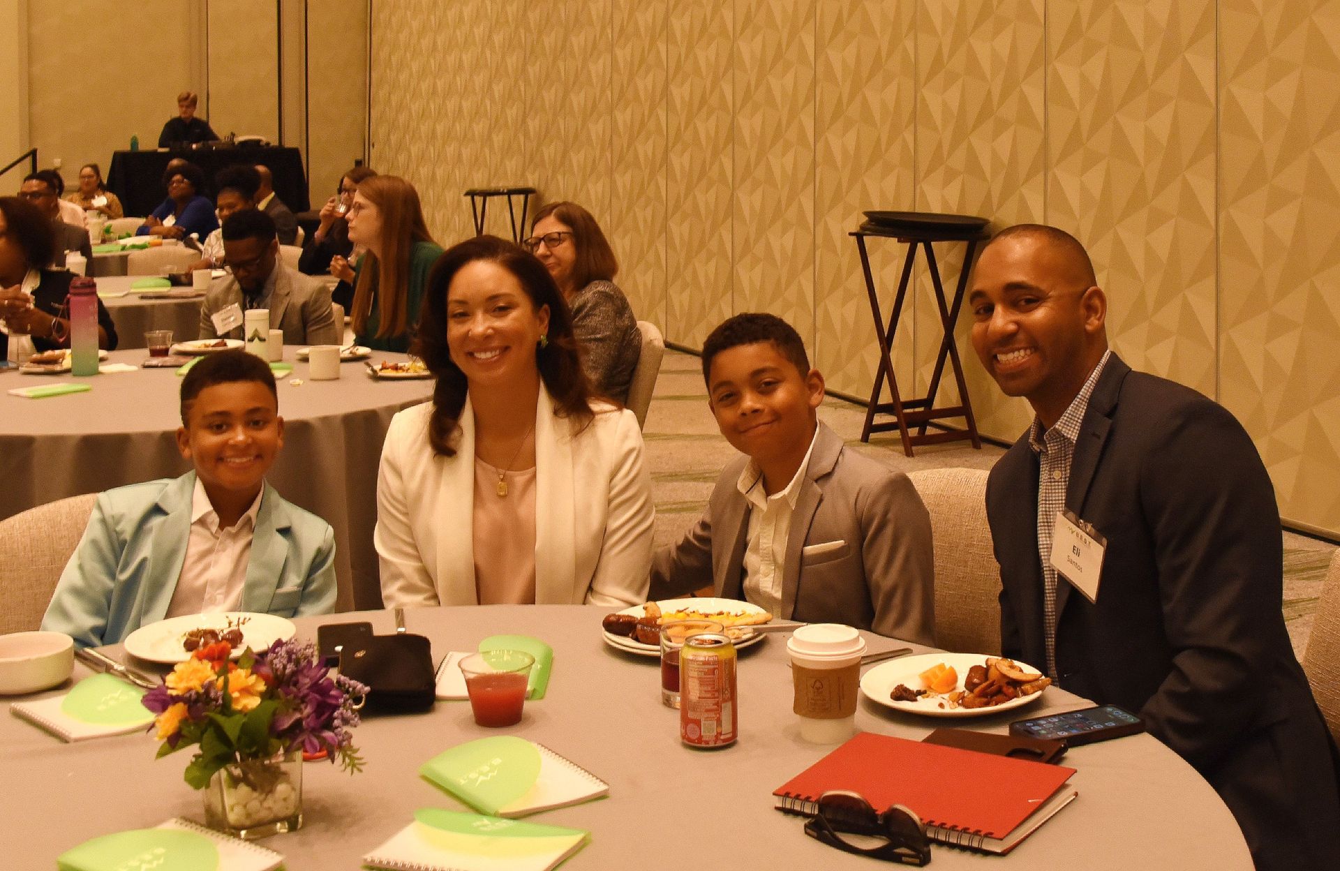 A group of people are sitting at a table with plates of food.