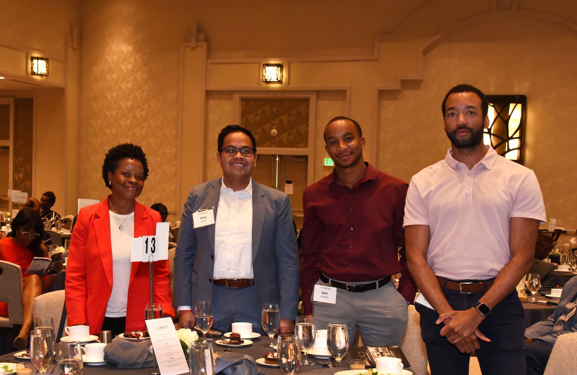 A group of people are posing for a picture at a dinner table.