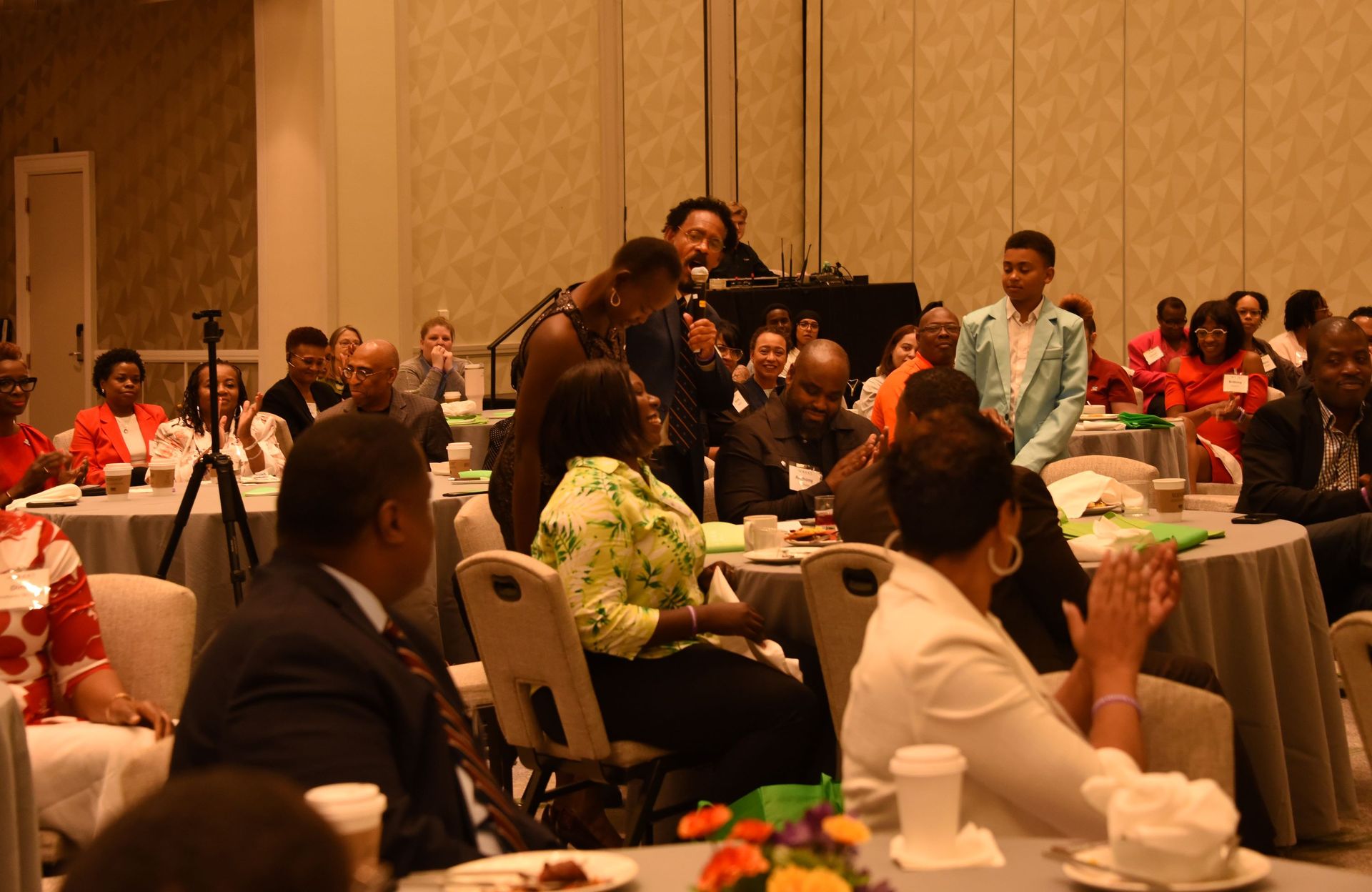 A group of people are sitting at tables at a conference.