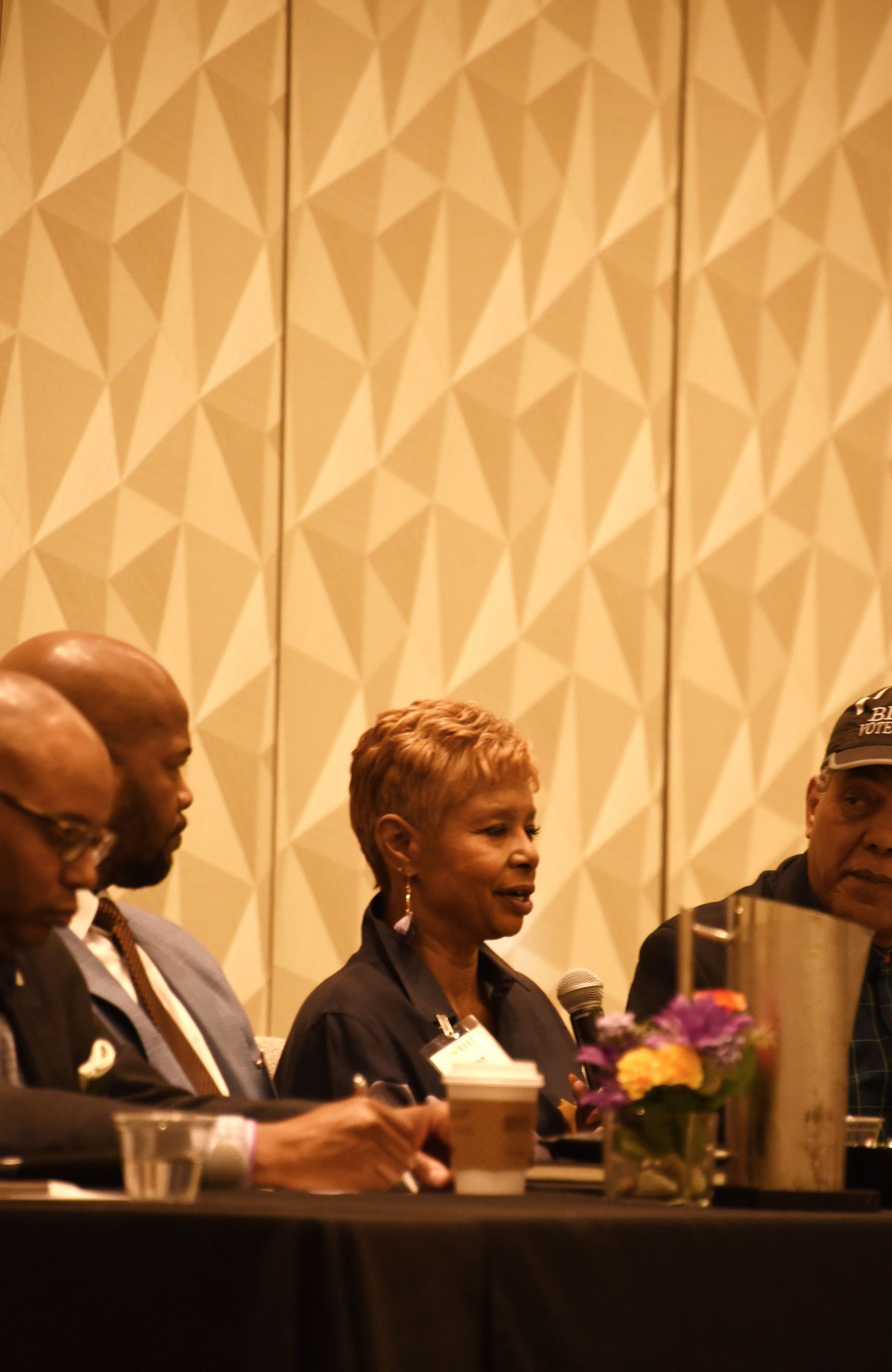 A group of people are sitting at a table talking to each other