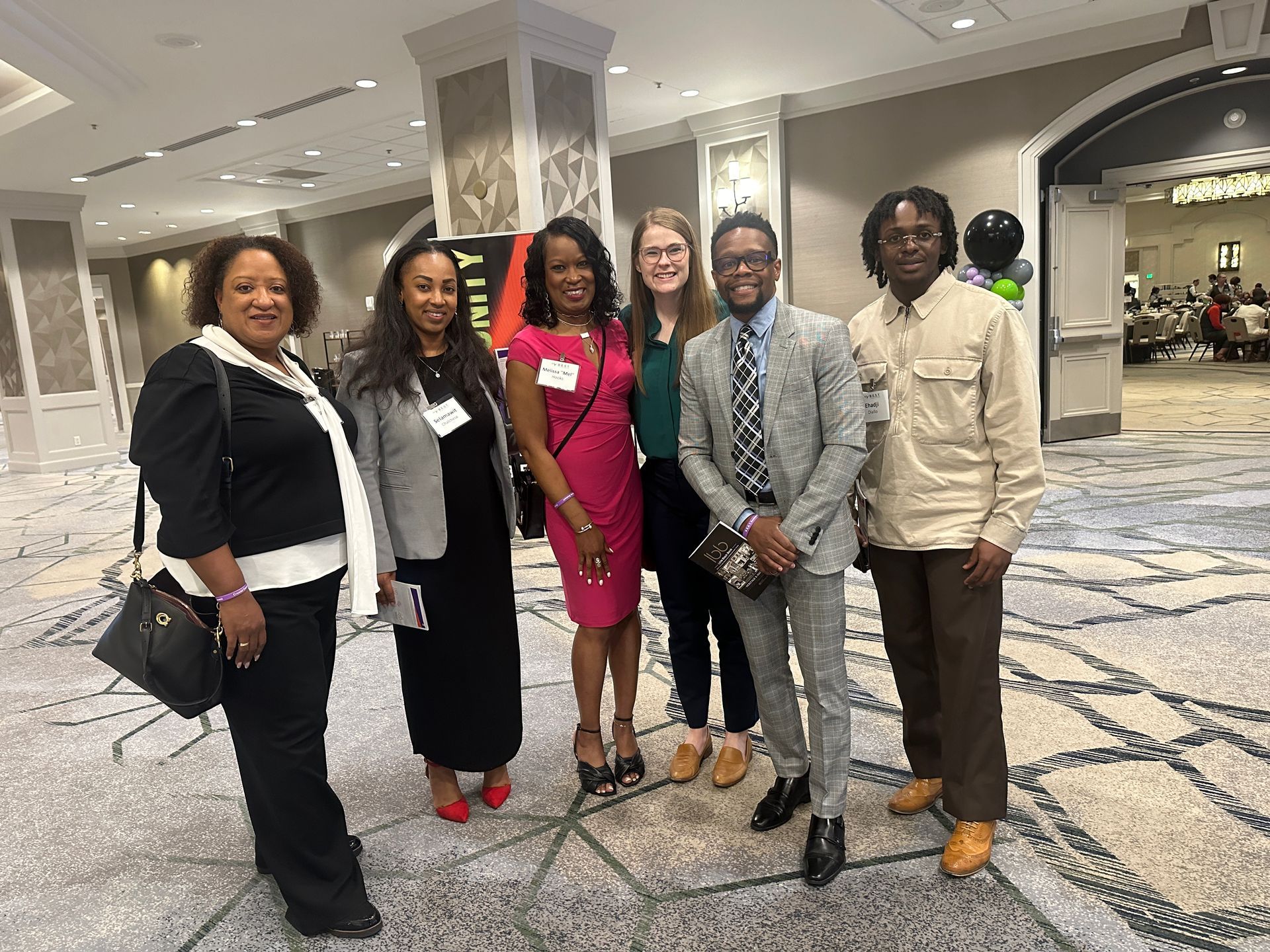 A group of people are posing for a picture in a hallway.