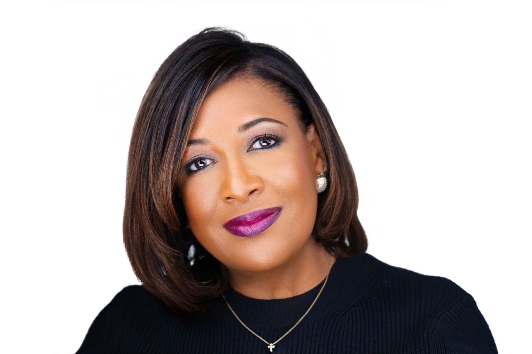 A woman wearing a black shirt and a necklace with a cross on it