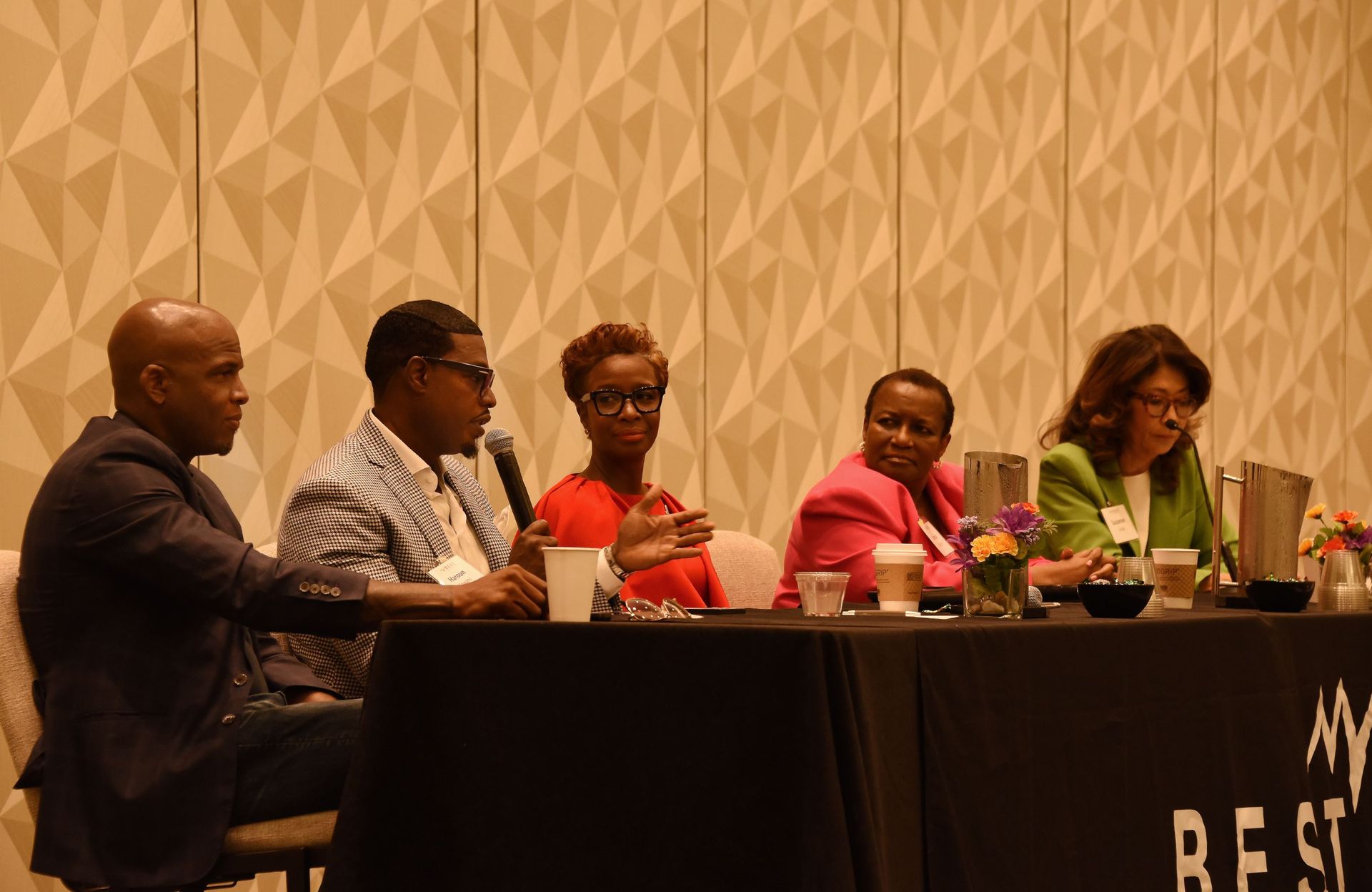 A group of people are sitting at a table talking to each other.