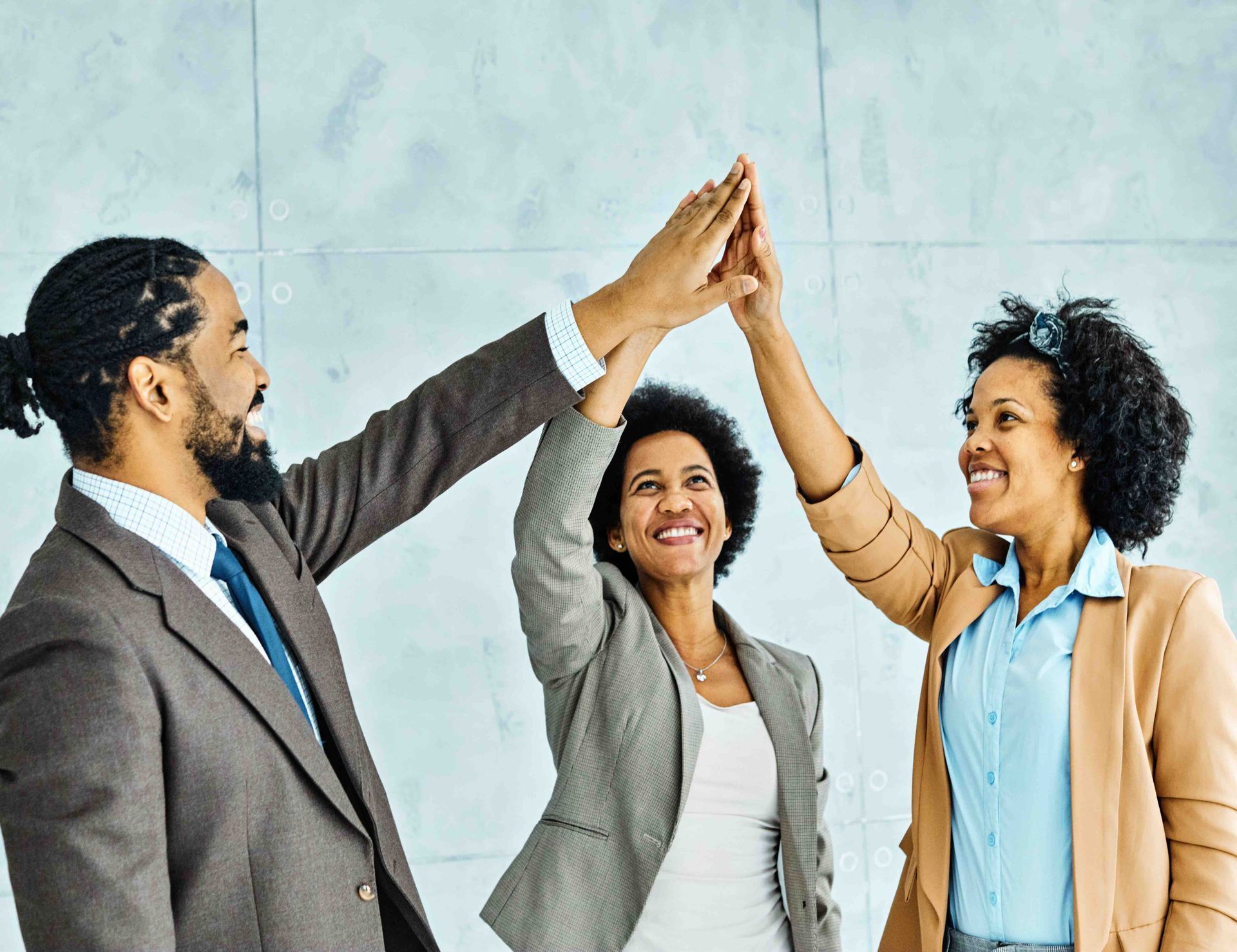 A group of business people are giving each other a high five.