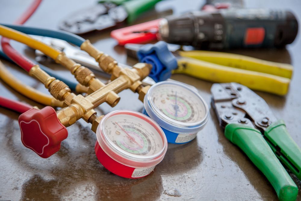 A bunch of tools are on a table including a pair of gauges.