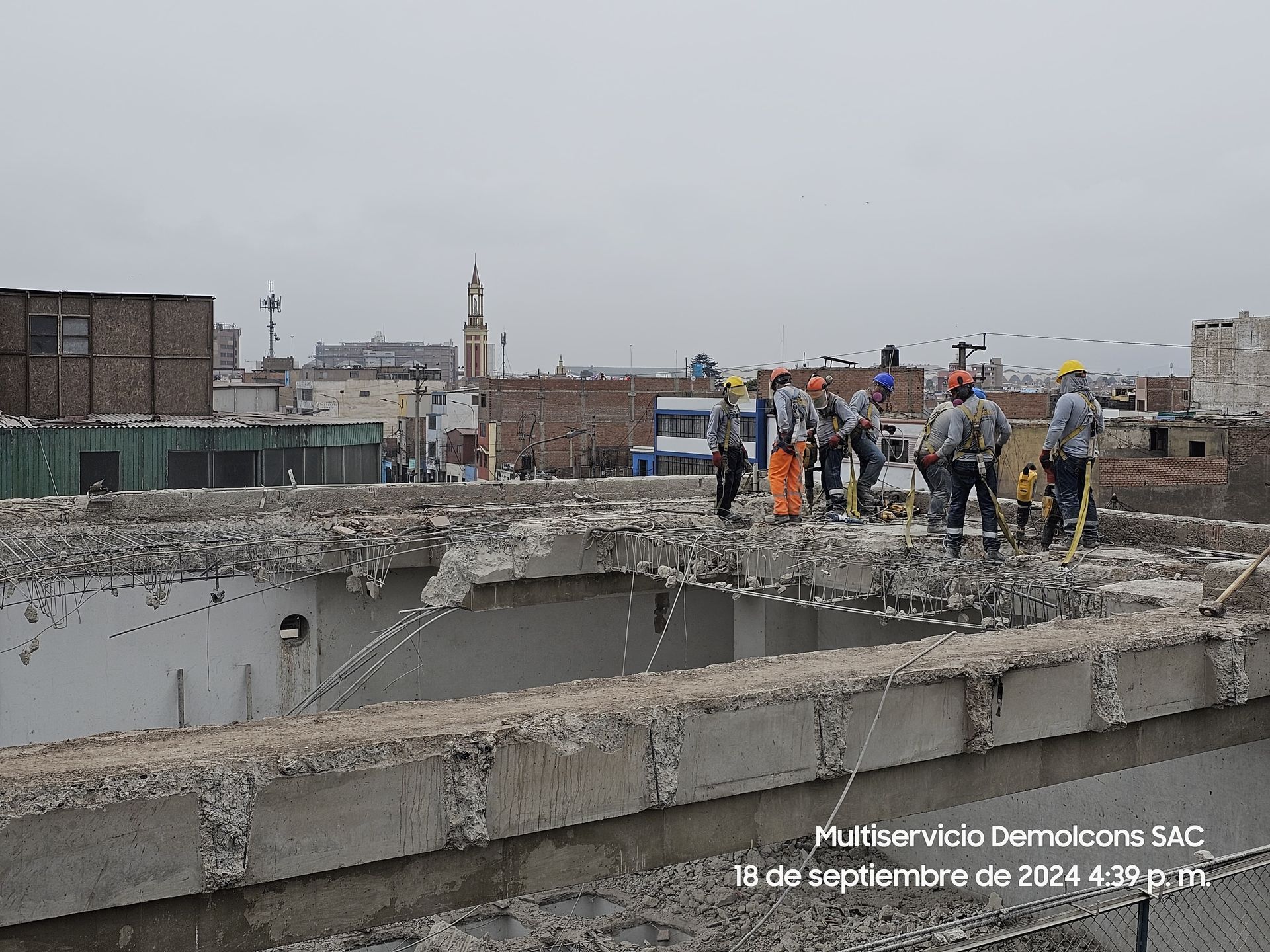 Un grupo de trabajadores de la construcción está de pie encima de una estructura de hormigón.