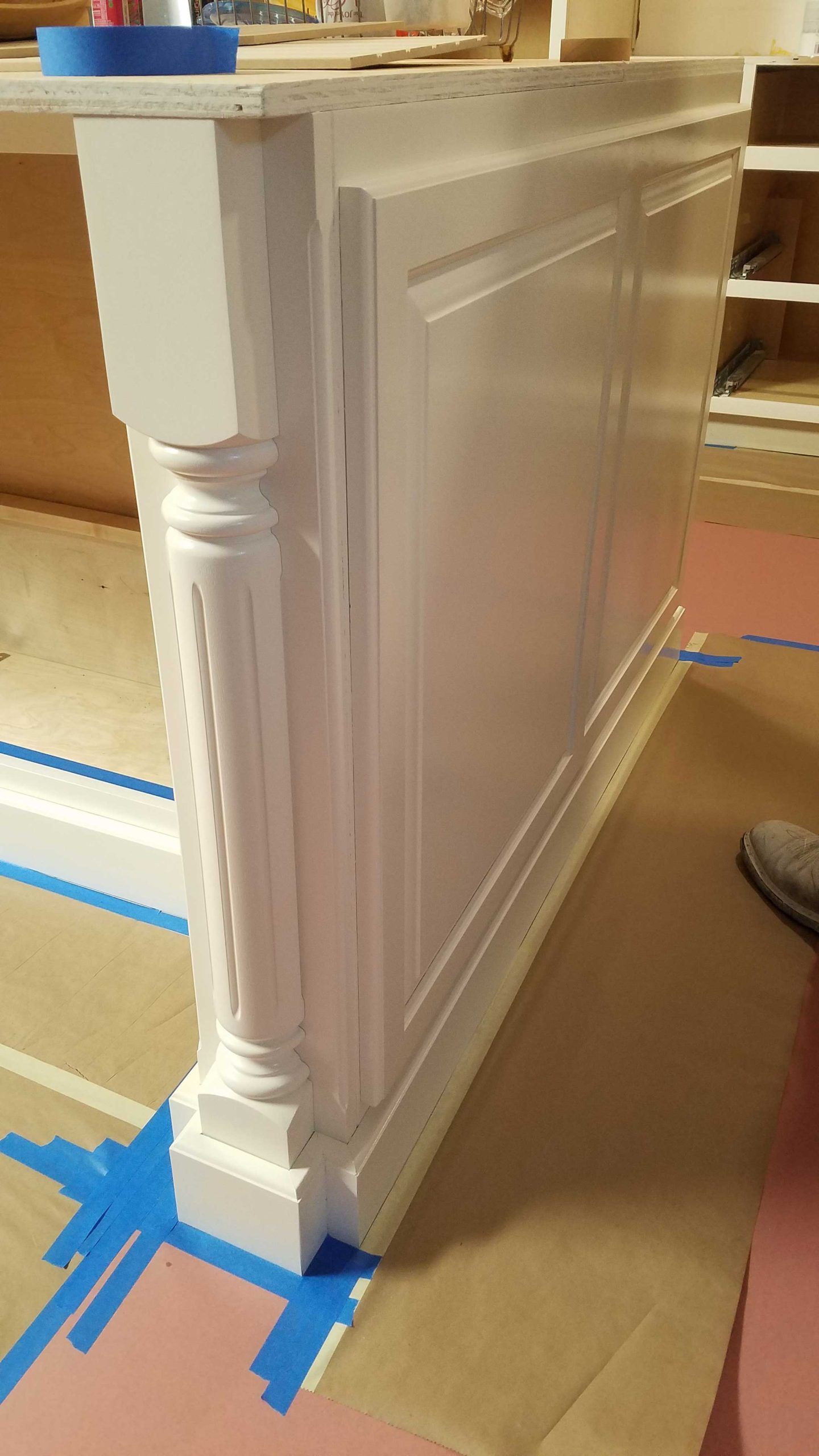 A white cabinet is being painted in a kitchen.