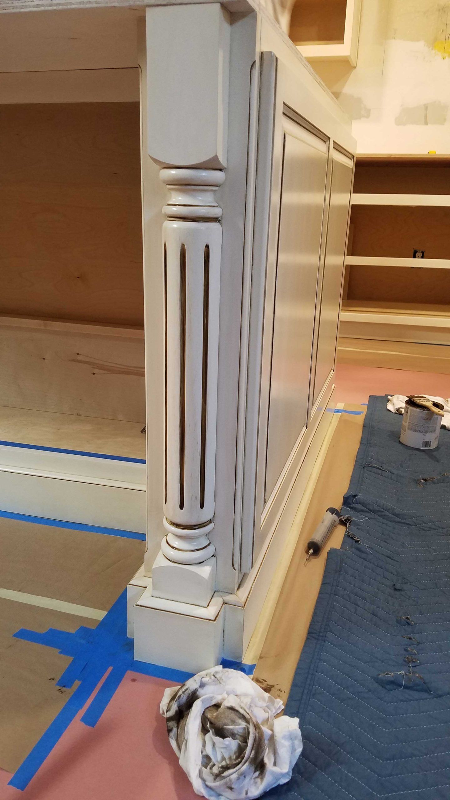 A white pillar is sitting on a wooden floor in a room.