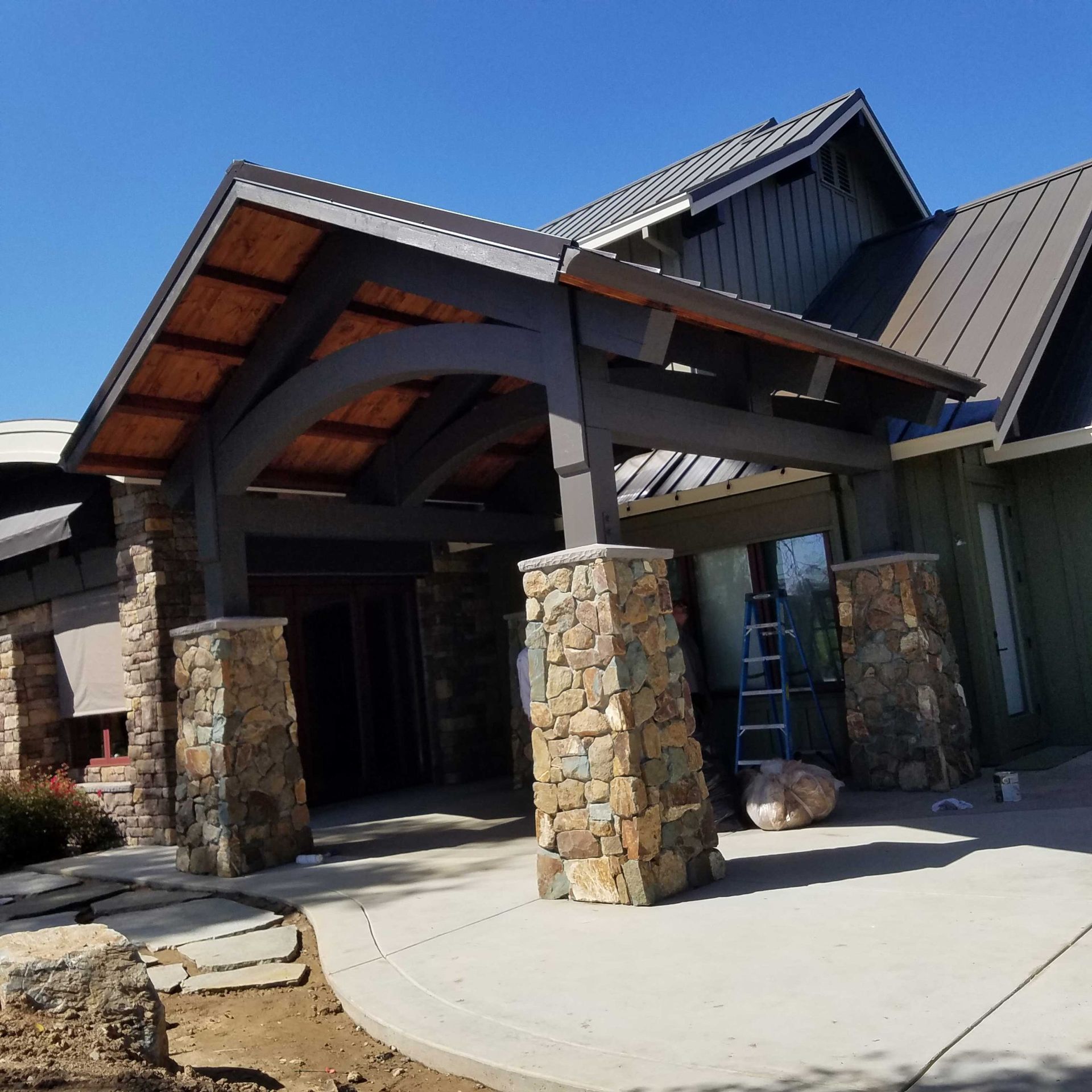 A large house with a wooden roof and stone pillars