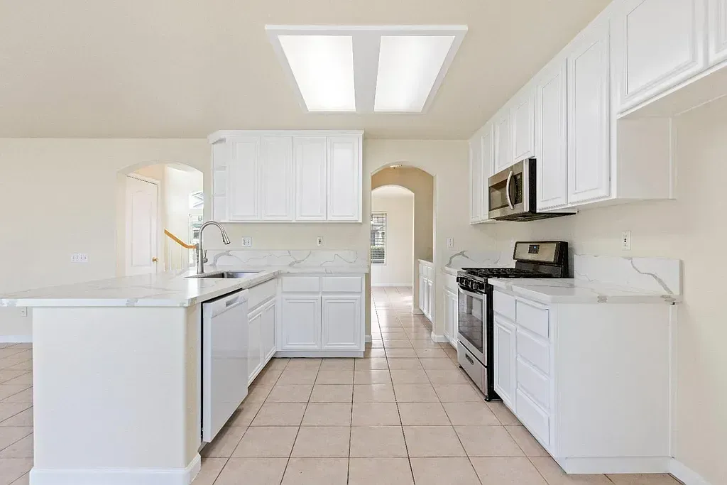 A kitchen with white cabinets and stainless steel appliances.
