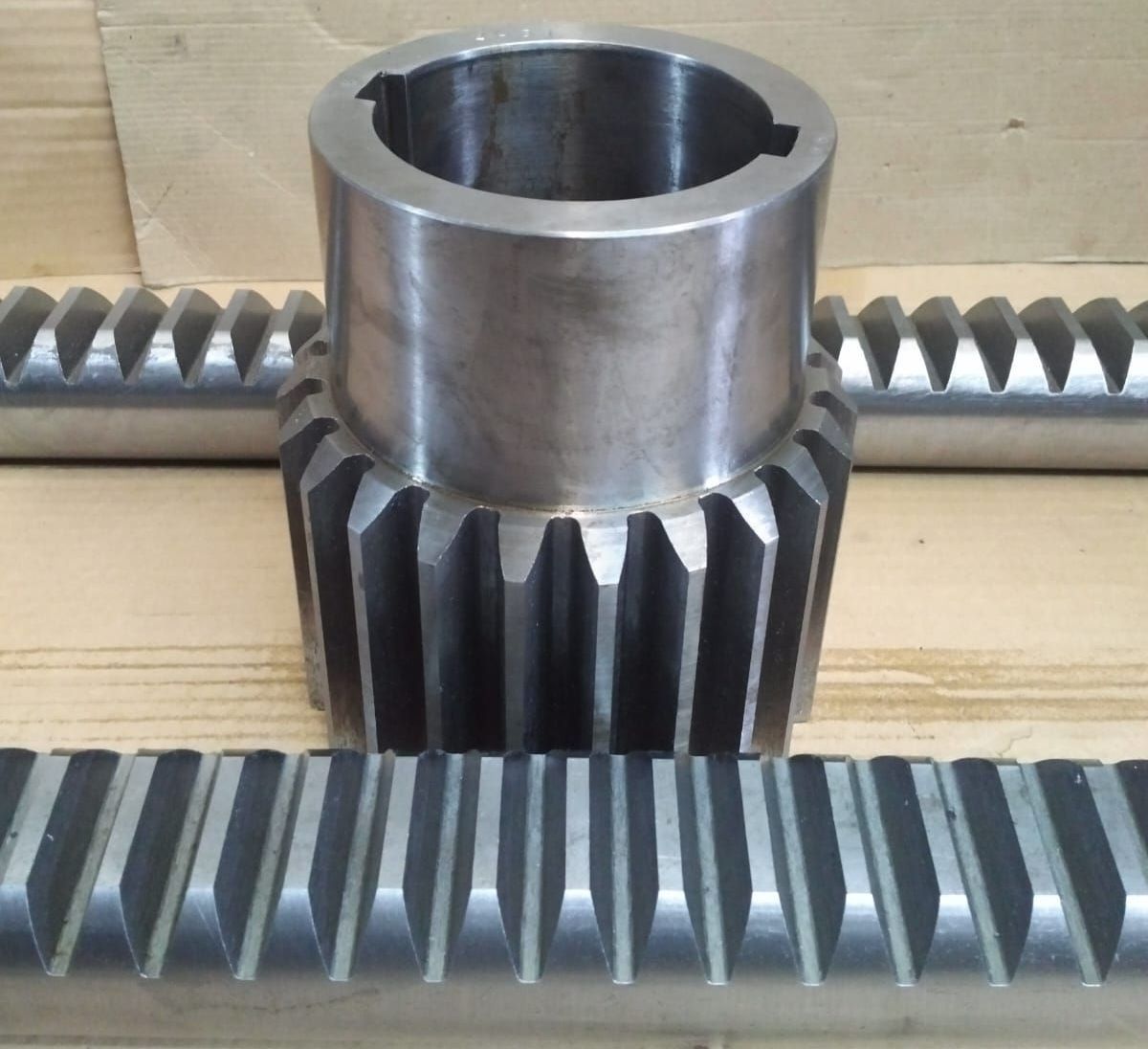 Sistema de engranajes metálicos y piñón y cremallera; engranaje cilíndrico entre dos cremalleras lineales.