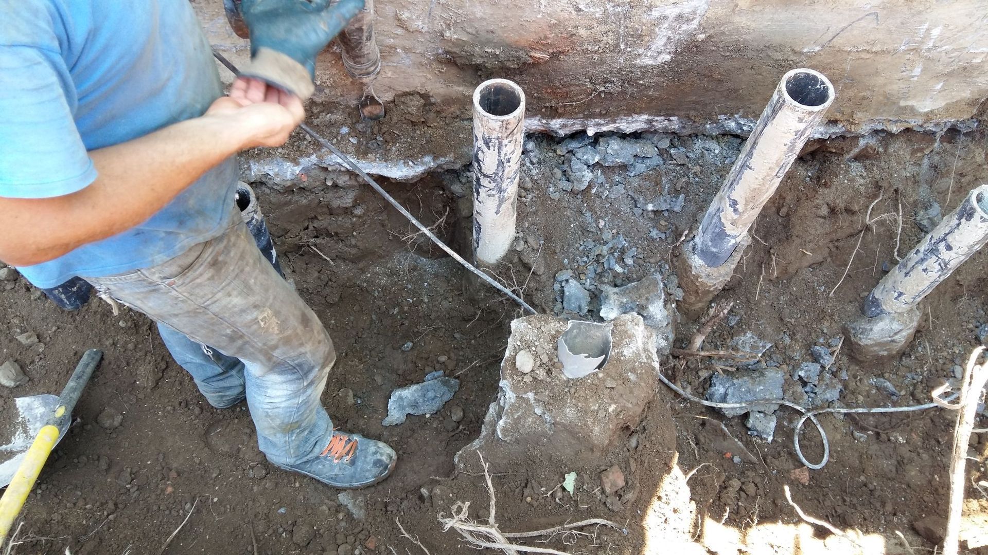 Un uomo con una camicia blu sta lavorando nella terra